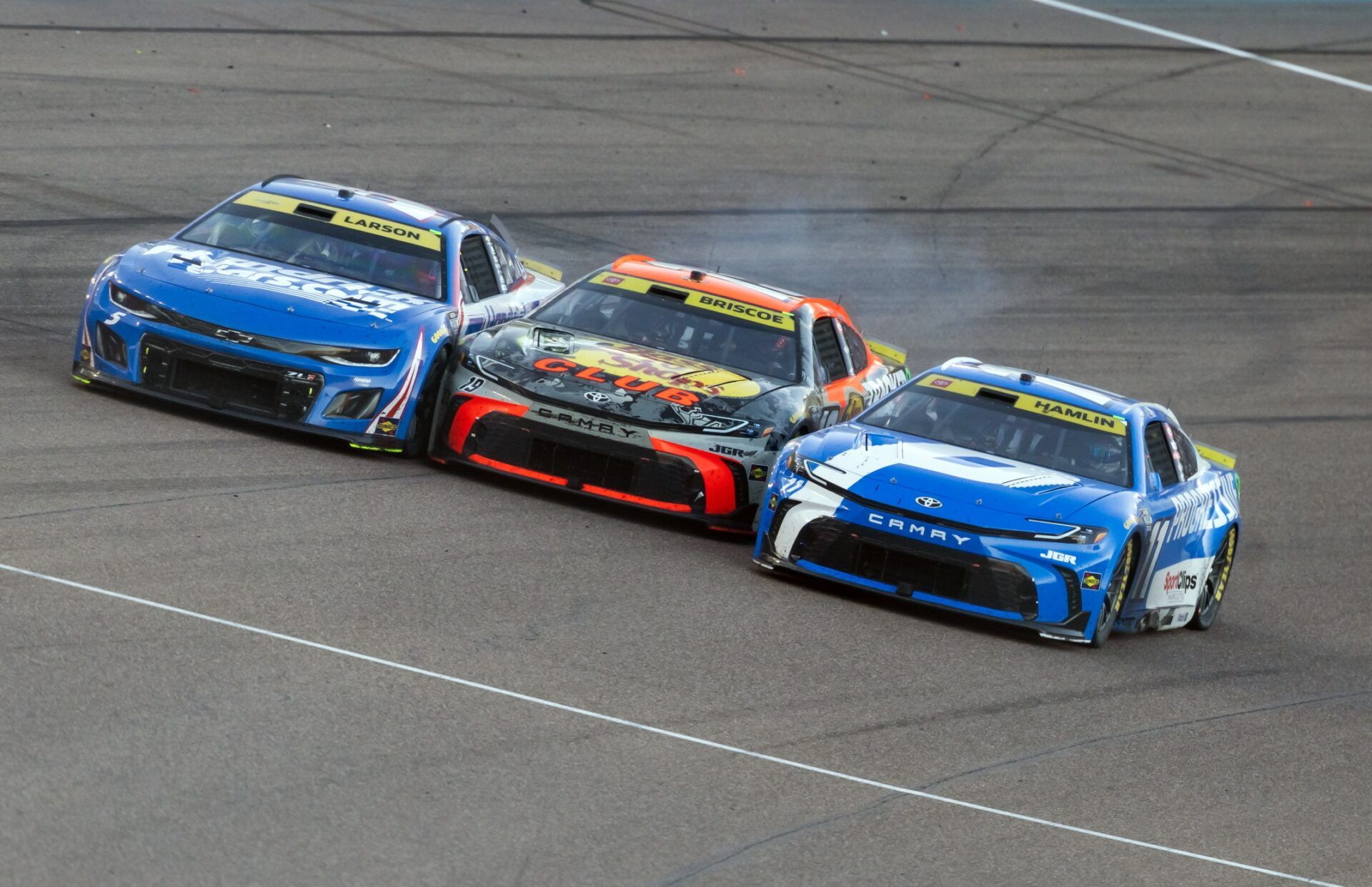 NASCAR Cup Series driver Kyle Larson (5) goes three wide with Chase Briscoe (19) and Denny Hamlin (11) during the NASCAR Championship race at Phoenix Raceway.