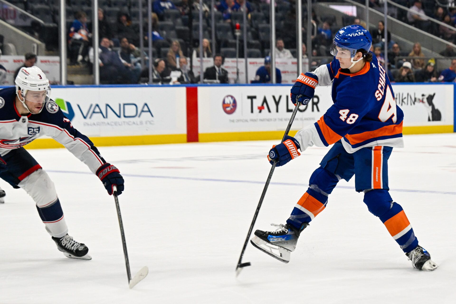 New York Islanders defenseman Matthew Schaefer (48) attempts a shot defended by Columbus Blue Jackets center Charlie Coyle (3) during the third period at UBS Arena.