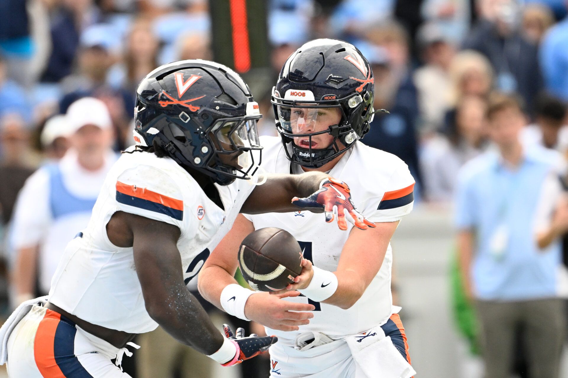Virginia Cavaliers quarterback Chandler Morris (4) hands the ball off to wide receiver Andre Greene Jr. (2) in the third quarter at Kenan Stadium.