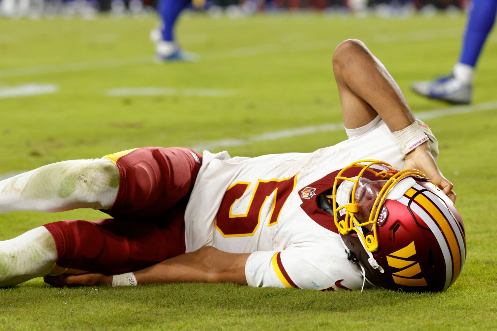Washington Commanders quarterback Jayden Daniels (5) reacts to an injury during the second half against the Washington Commanders at Northwest Stadium.