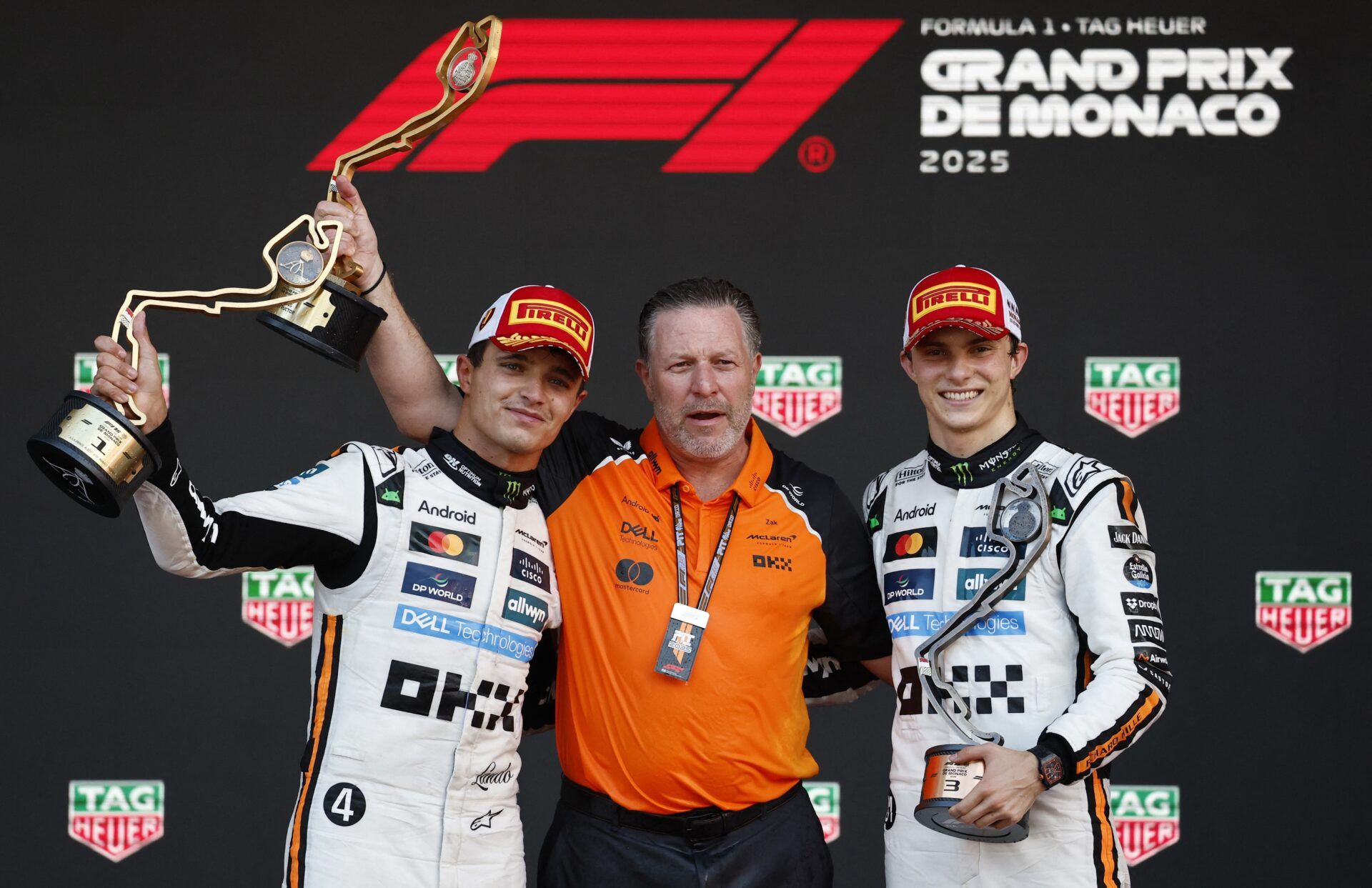 [US, Mexico & Canada customers only] May 25, 2025; MONACO; McLaren's Lando Norris celebrates with a trophy on the podium after winning the Monaco Grand Prix alongside third placed McLaren's Oscar Piastri and McLaren chief executive Zak Brown at Circuit de Monaco.