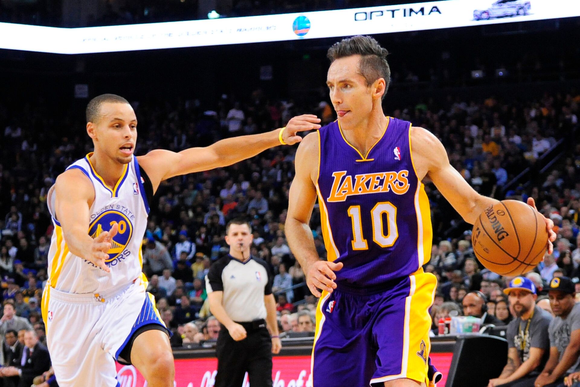 Los Angeles Lakers point guard Steve Nash (10) dribbles the ball against Golden State Warriors point guard Stephen Curry (30) during the first quarter at ORACLE Arena.