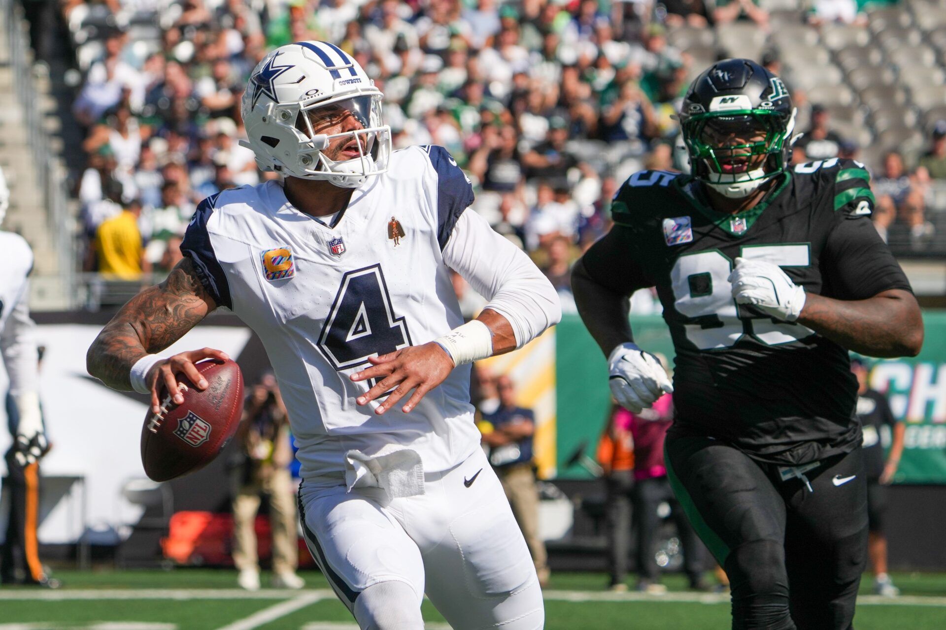 Dallas Cowboys quarterback Dak Prescott (4) looks to pass downfield as New York Jets defensive tackle Quinnen Williams (95) defends during the first half at MetLife Stadium.