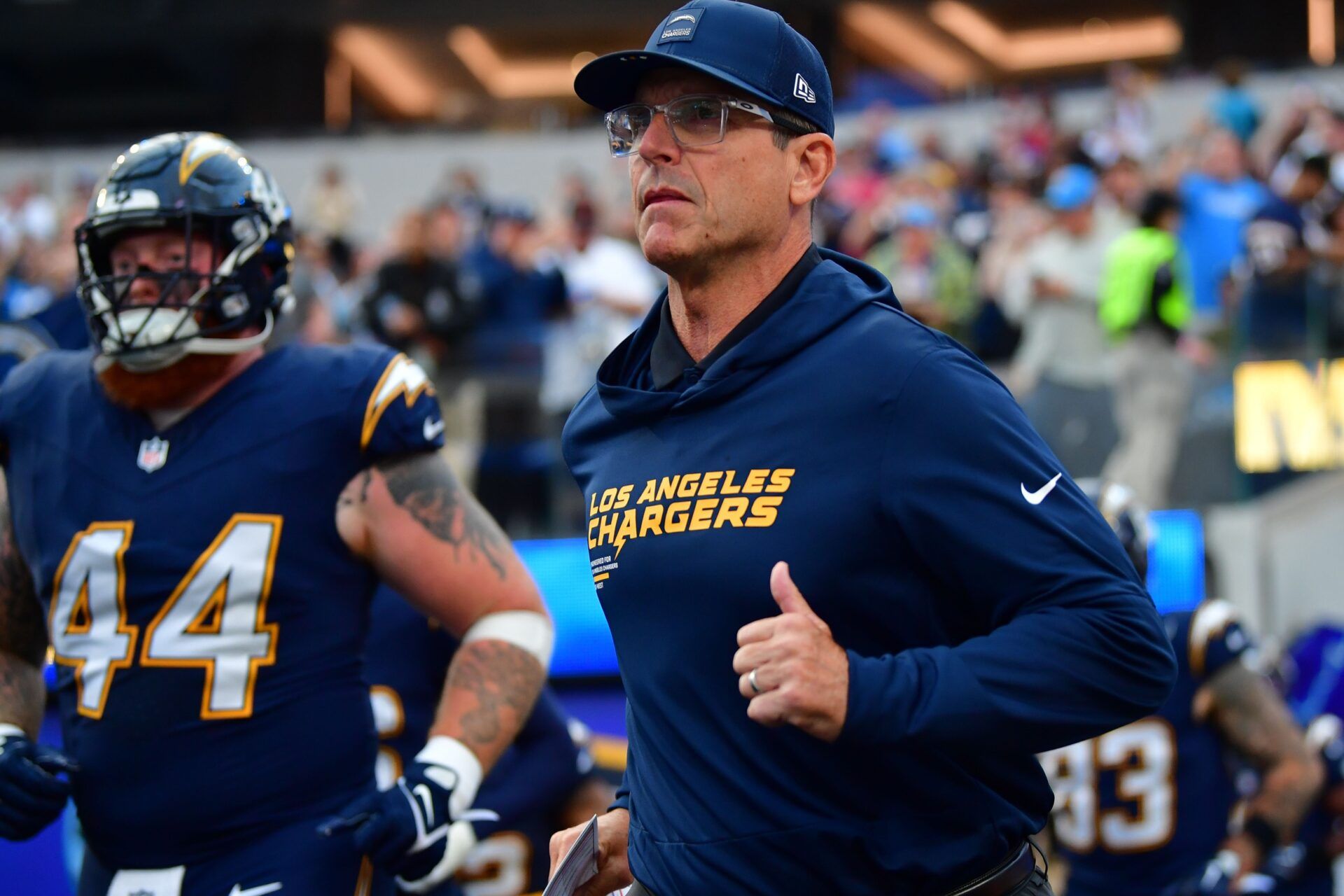 Los Angeles Chargers head coach Jim Harbaugh takes the field against the Minnesota Vikings before the game at SoFi Stadium.