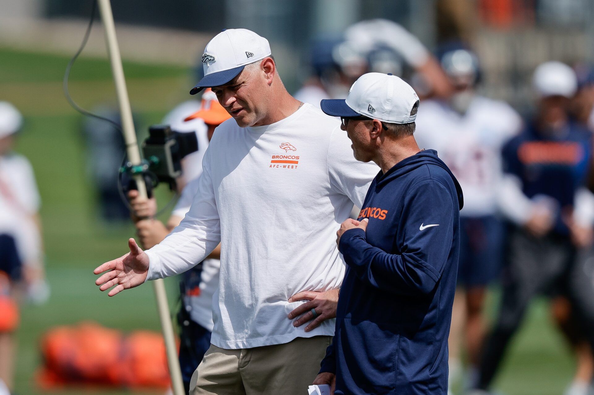 Denver Broncos offensive coordinator Joe Lombardi (L) and offensive assistant Pete Carmichael (R) during Denver Broncos Training Camp.