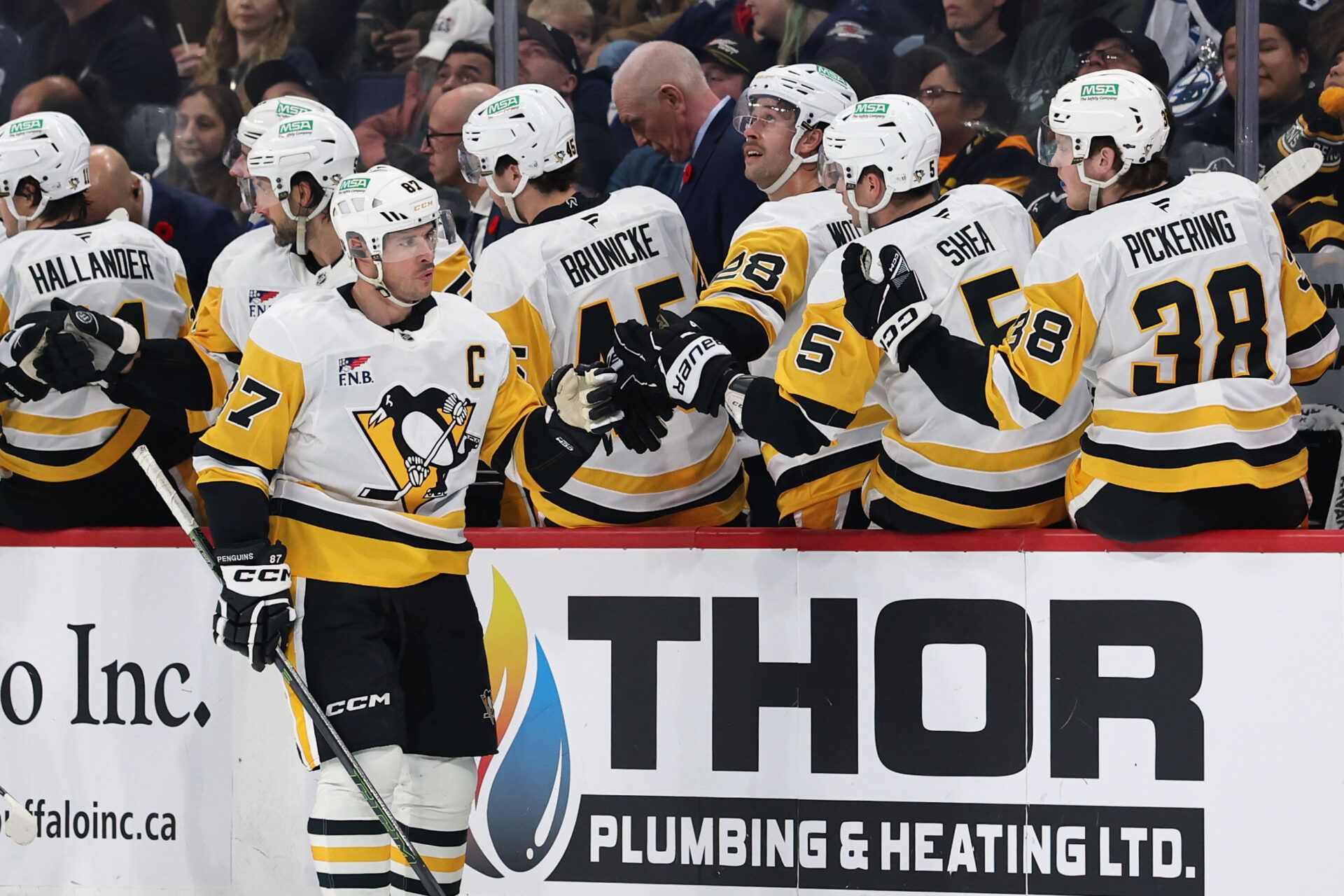 Pittsburgh Penguins center Sidney Crosby (87) shakes hands with his teammates on the bench after scoring a goal against the Winnipeg Jets in the second period at Canada Life Centre.