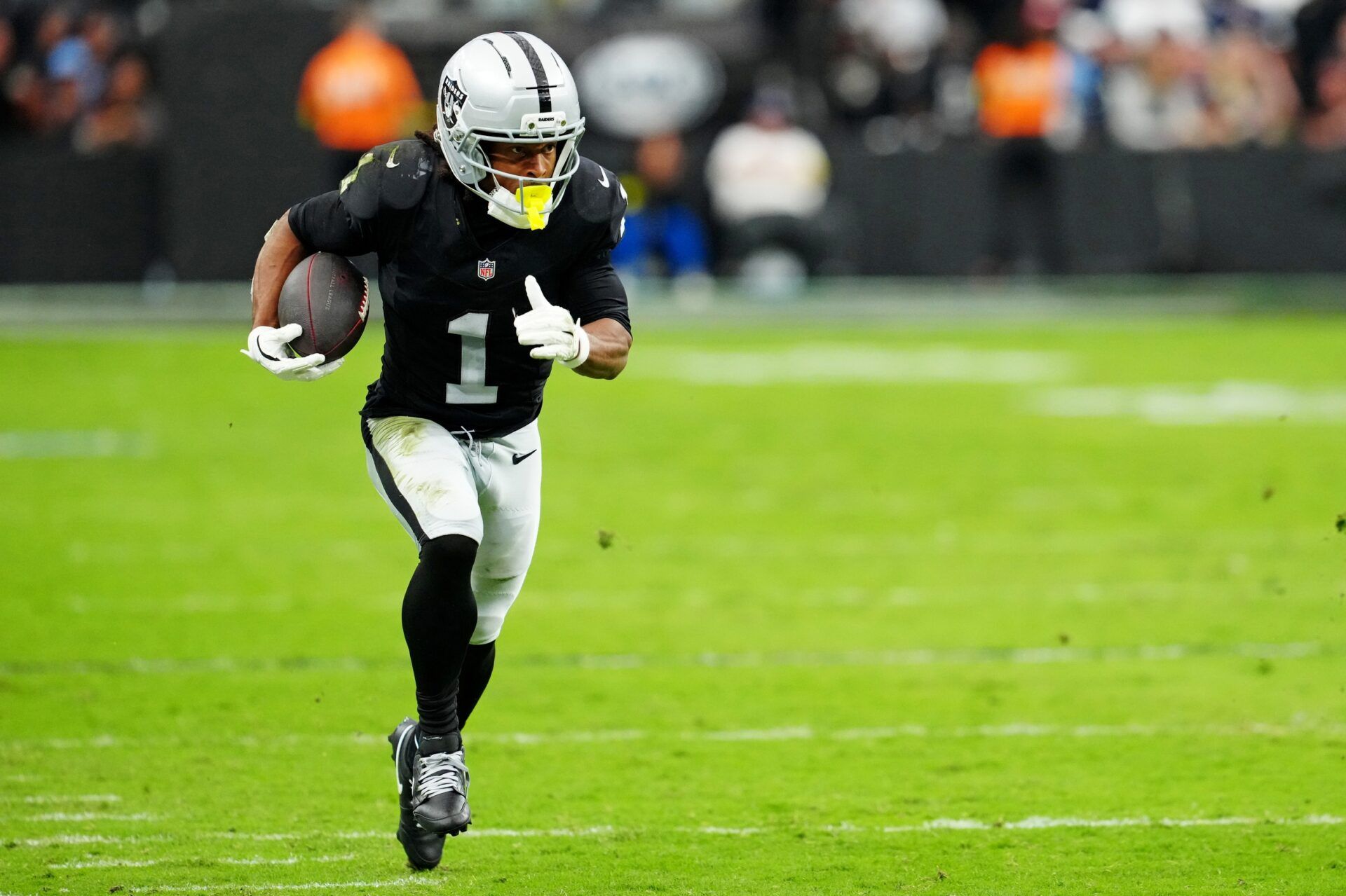 Las Vegas Raiders wide receiver Tre Tucker (1) runs the ball down the field during the second half against the Tennessee Titans at Allegiant Stadium.