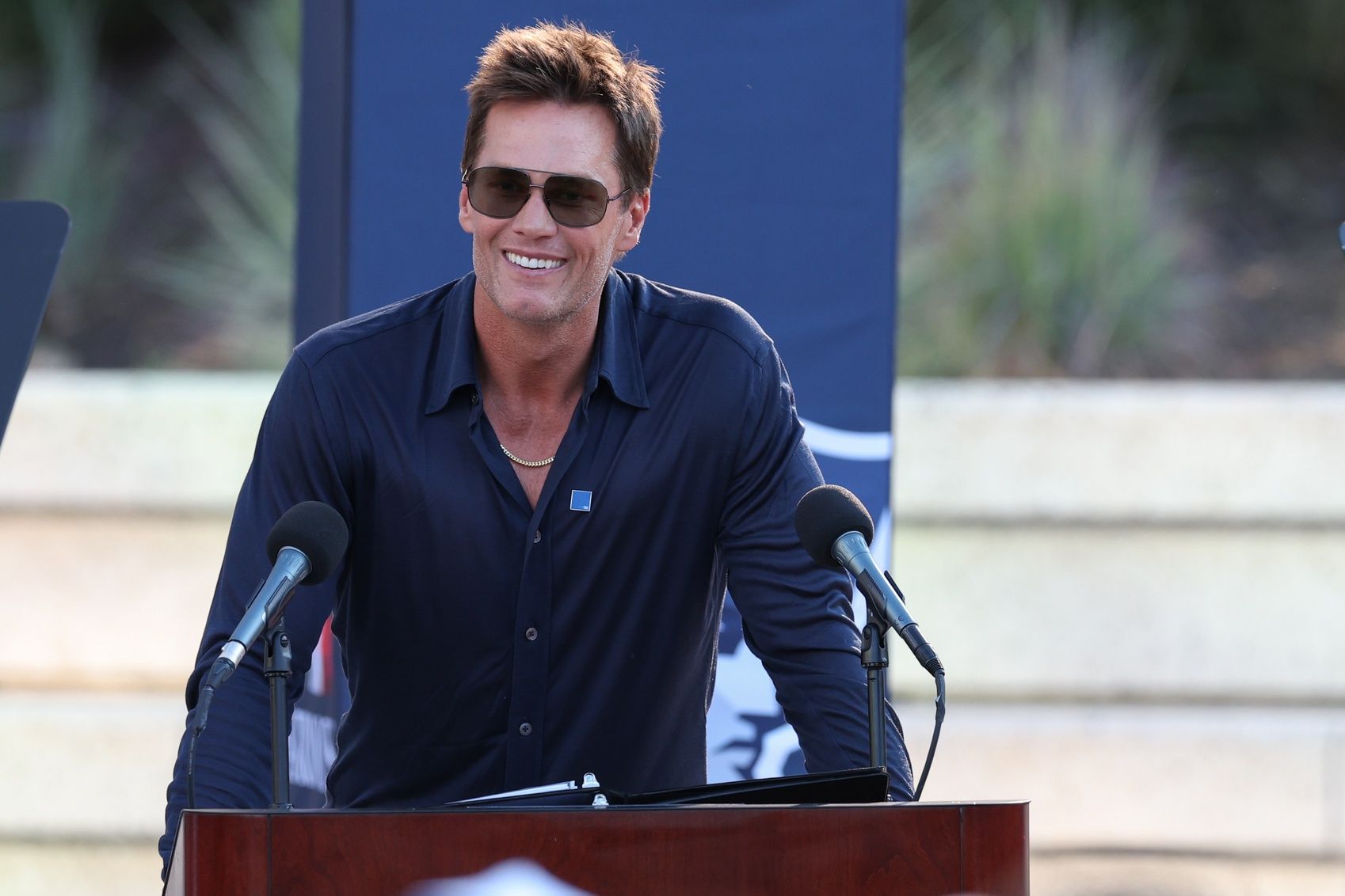 Retired New England Patriot Hall of Famer Tom Brady speaks during a statue unveiling before a game against the Washington Commanders at Gillette Stadium.