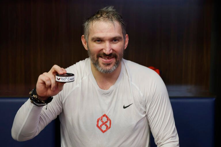 Washington Capitals left wing Alex Ovechkin holds the puck from his 900th NHL goal after the Capitals' game against the St. Louis Blues at Capital One Arena.
