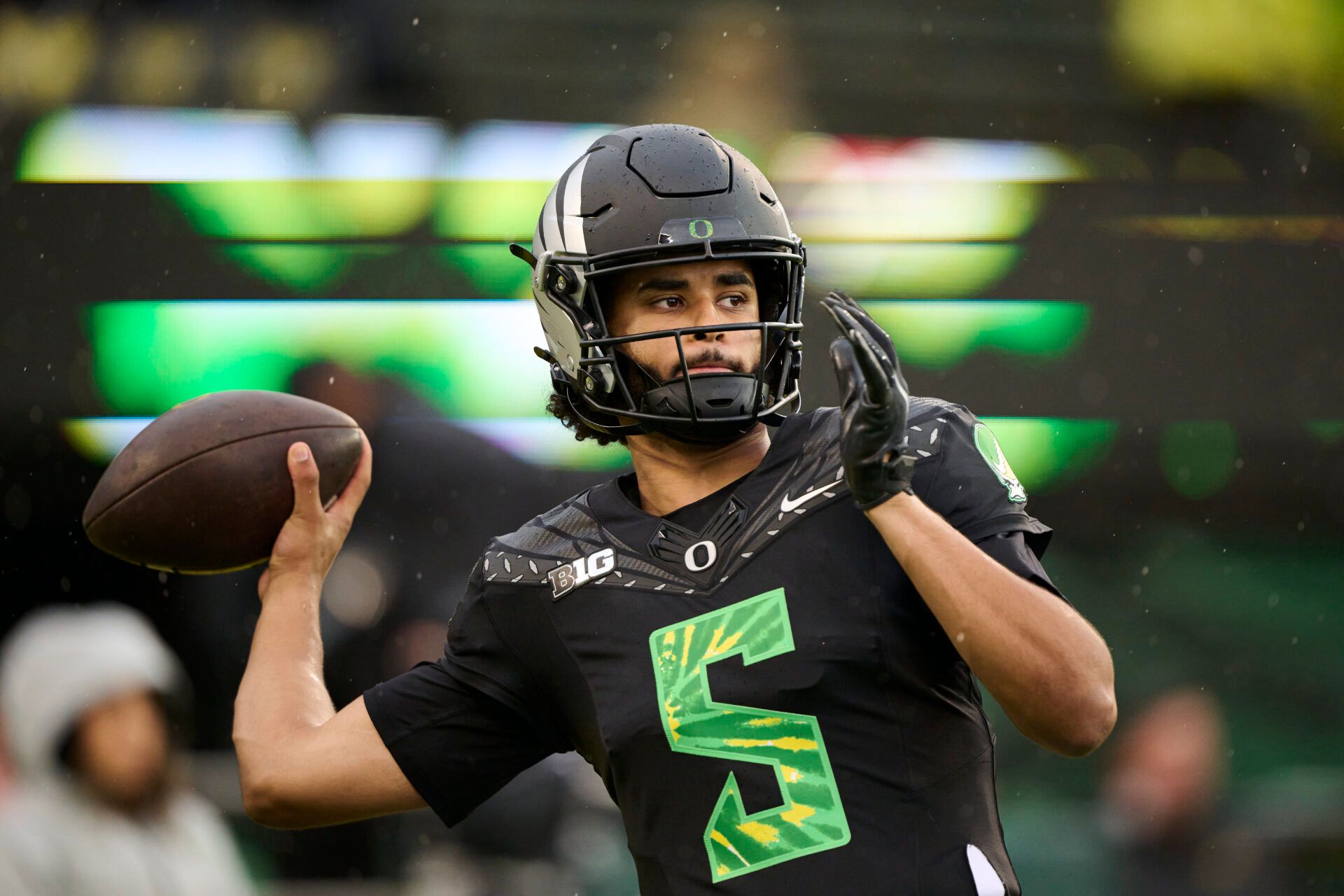 Oregon Ducks quarterback Dante Moore (5) warms up before a game against the Wisconsin Badgers at Autzen Stadium. The Ducks are wearing uniforms celebrating the Grateful Dead.