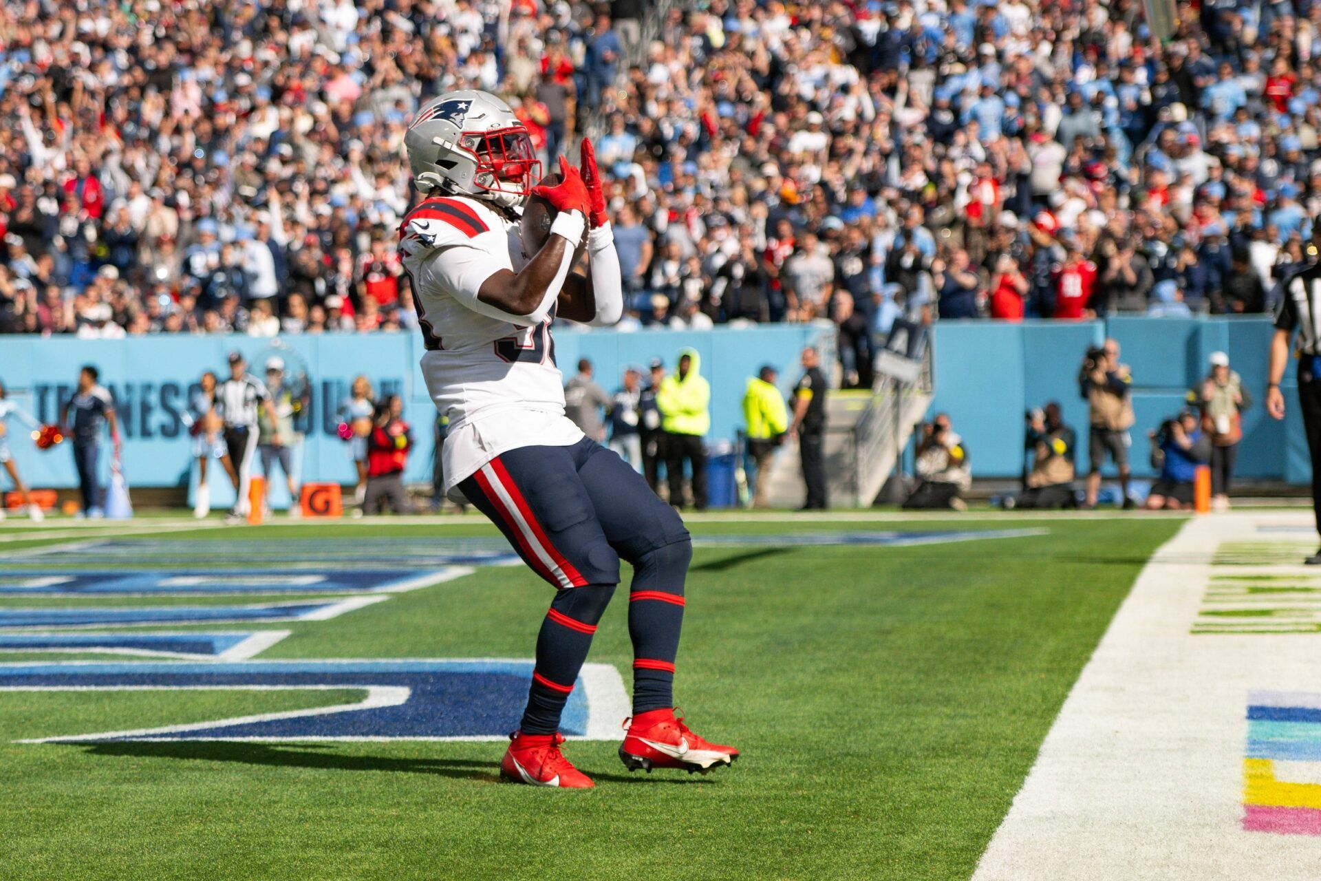 New England Patriots running back Rhamondre Stevenson (38) celebrates with his teammates after touchdown against the Tennessee Titans during the second half at Nissan Stadium.
