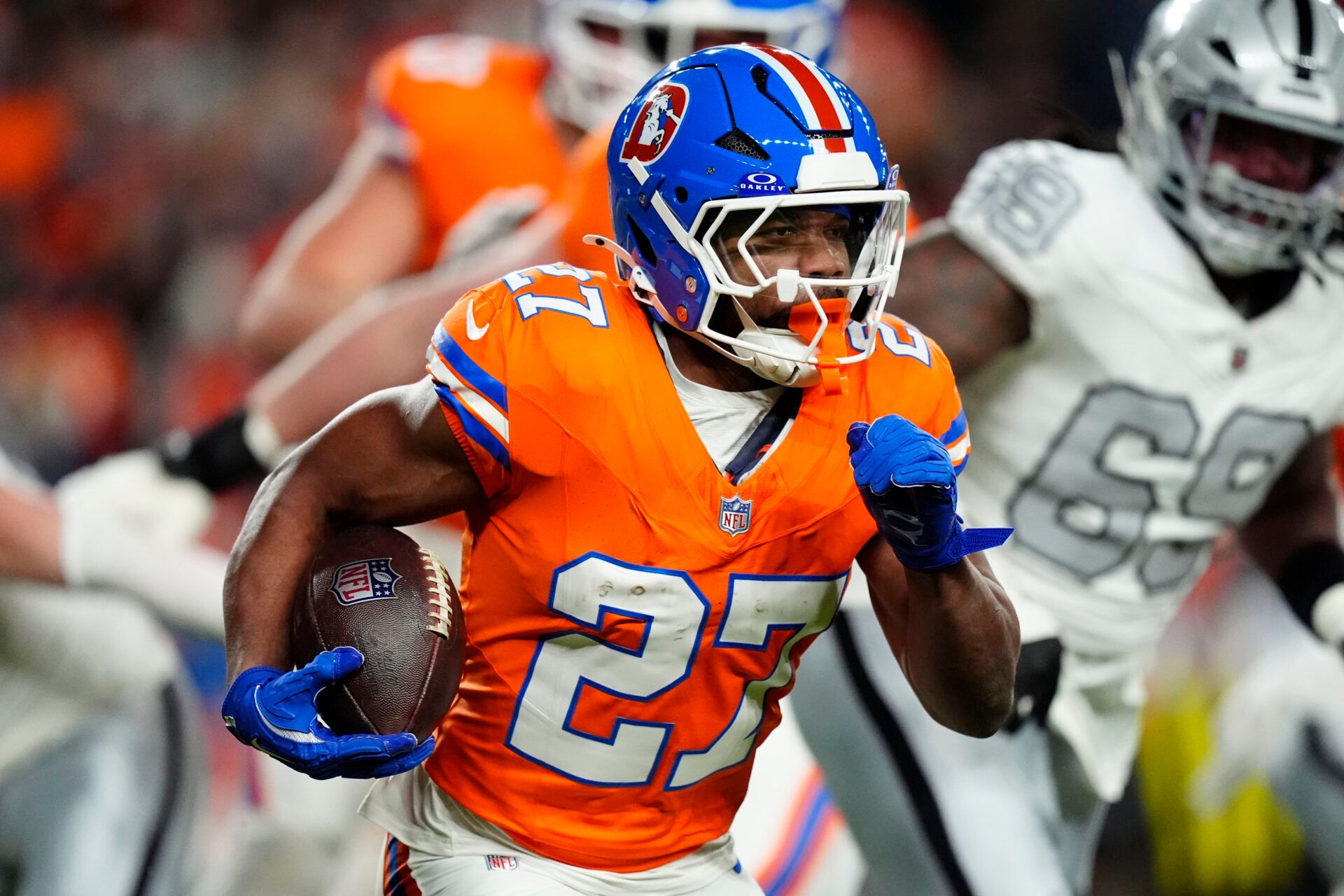 Denver Broncos running back J.K. Dobbins (27) rushes the ball against the Las Vegas Raiders during the first half at Empower Field at Mile High.