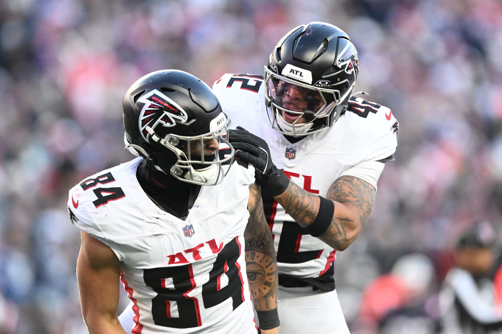Atlanta Falcons tight end Feleipe Franks (84) and linebacker Josh Woods (42) celebrate a return stop against the New England Patriots during the fourth quarter at Gillette Stadium.