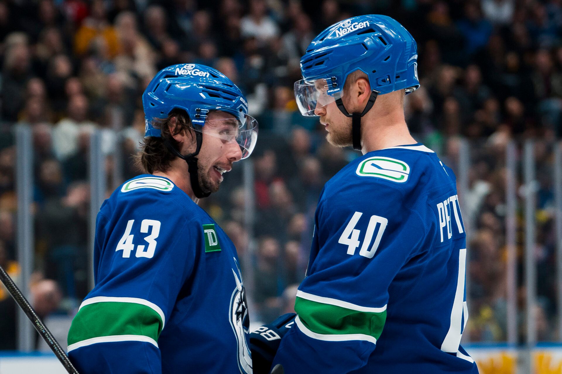 Vancouver Canucks defenseman Quinn Hughes (43) talks with forward Elias Pettersson (40) during a stop in play against the Chicago Blackhawks in the second period at Rogers Arena.