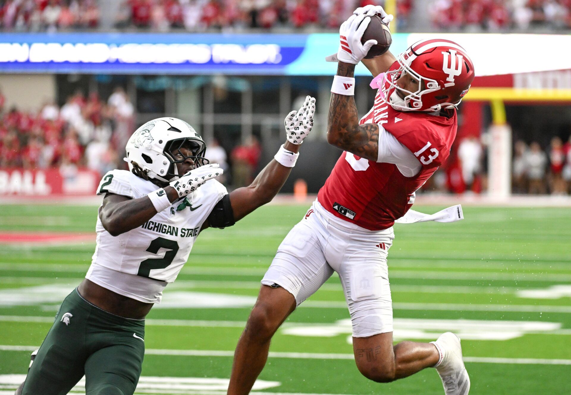 Indiana Hoosiers wide receiver Elijah Sarratt (13) catches a pass for a touchdown against Michigan State Spartans defensive back Aydan West (2) during the second half at Memorial Stadium.