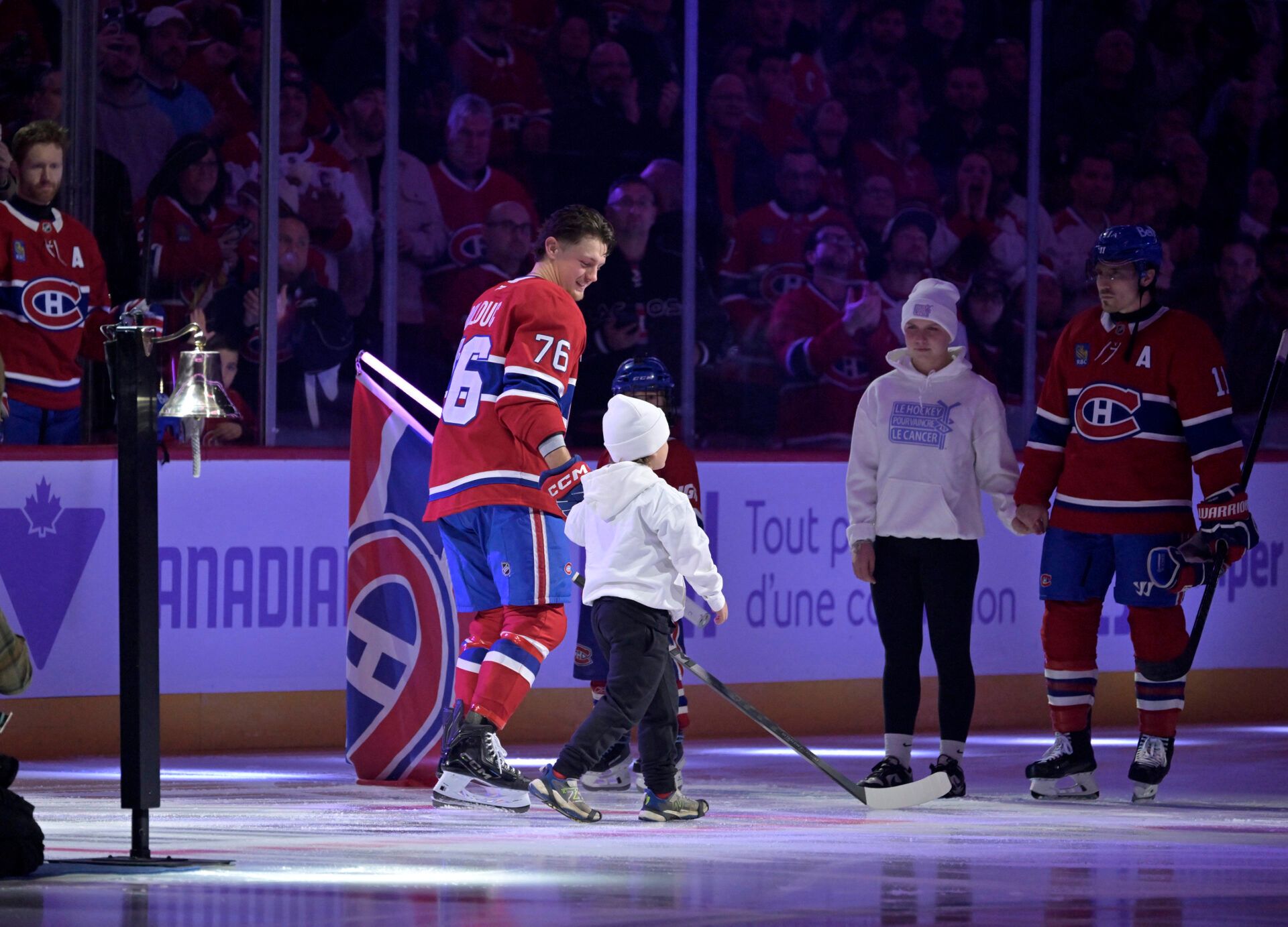 Montreal Canadiens forward Zack Bolduc (76) and teammate forward Brendan Gallagher (11) with youths celebrating Hockey fights cancer before the game against the Utah Mammoth at the Bell Centre.