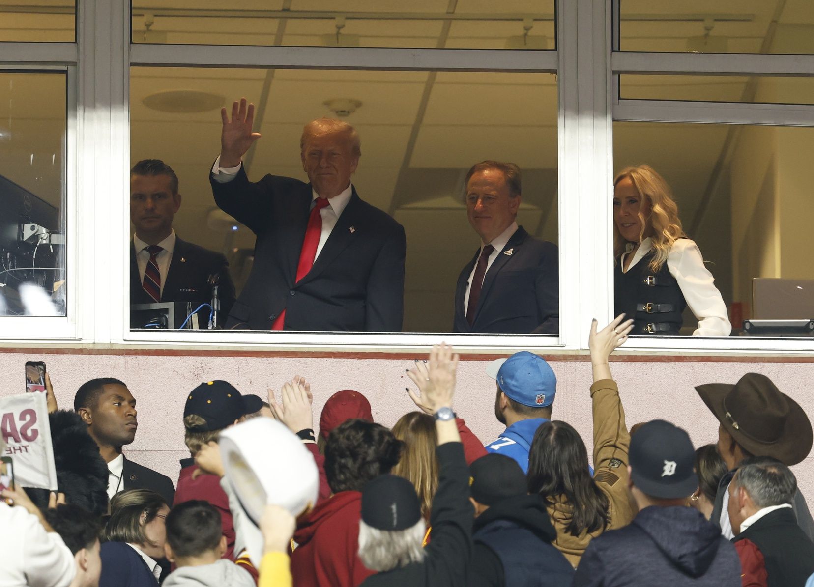President Donald Trump waves during the second quarter of a game between the Washington Commanders and the Detroit Lions at Northwest Stadium.