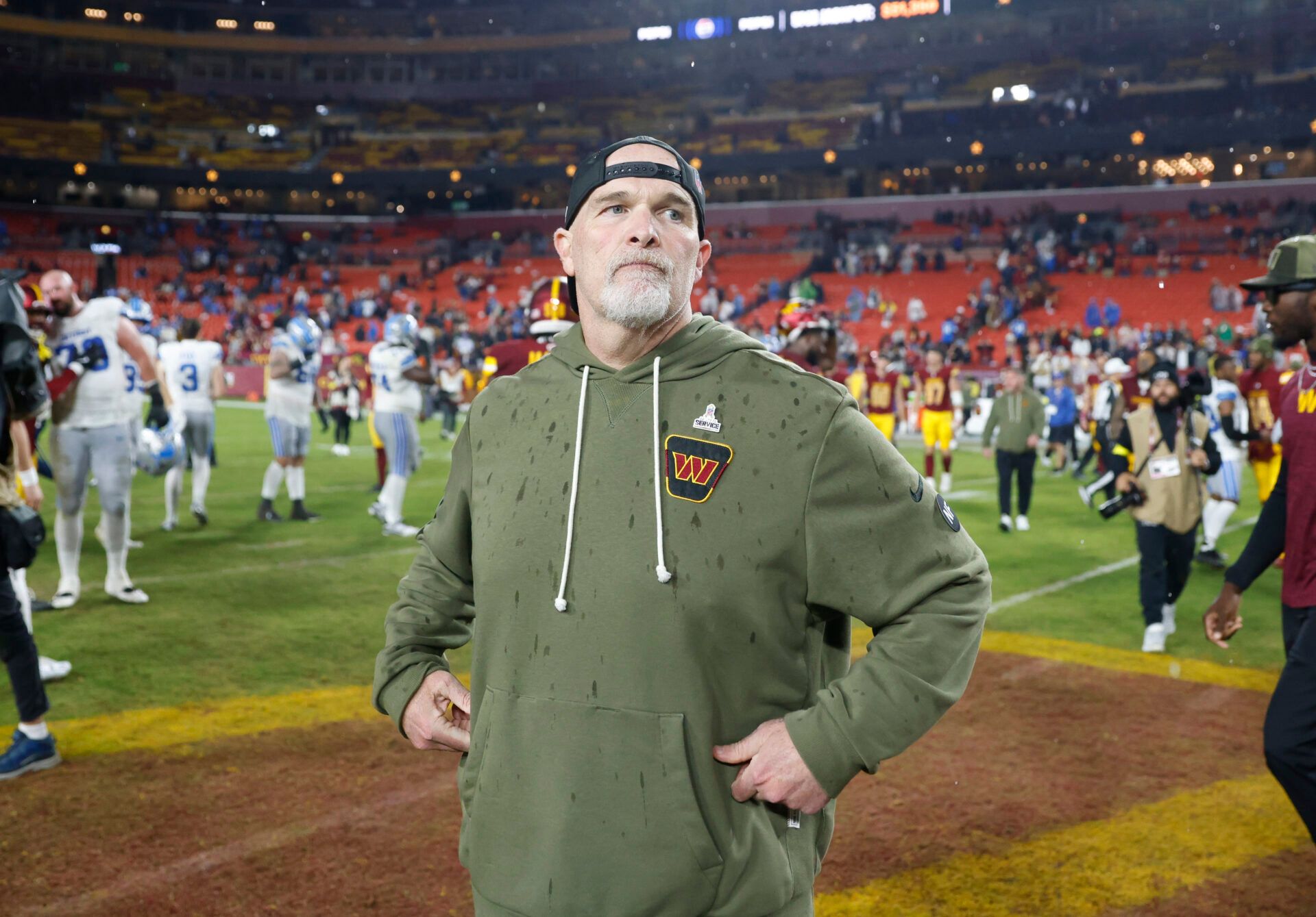 Washington Commanders head coach Dan Quinn stands on the field following a loss to the Detroit Lions at Northwest Stadium.