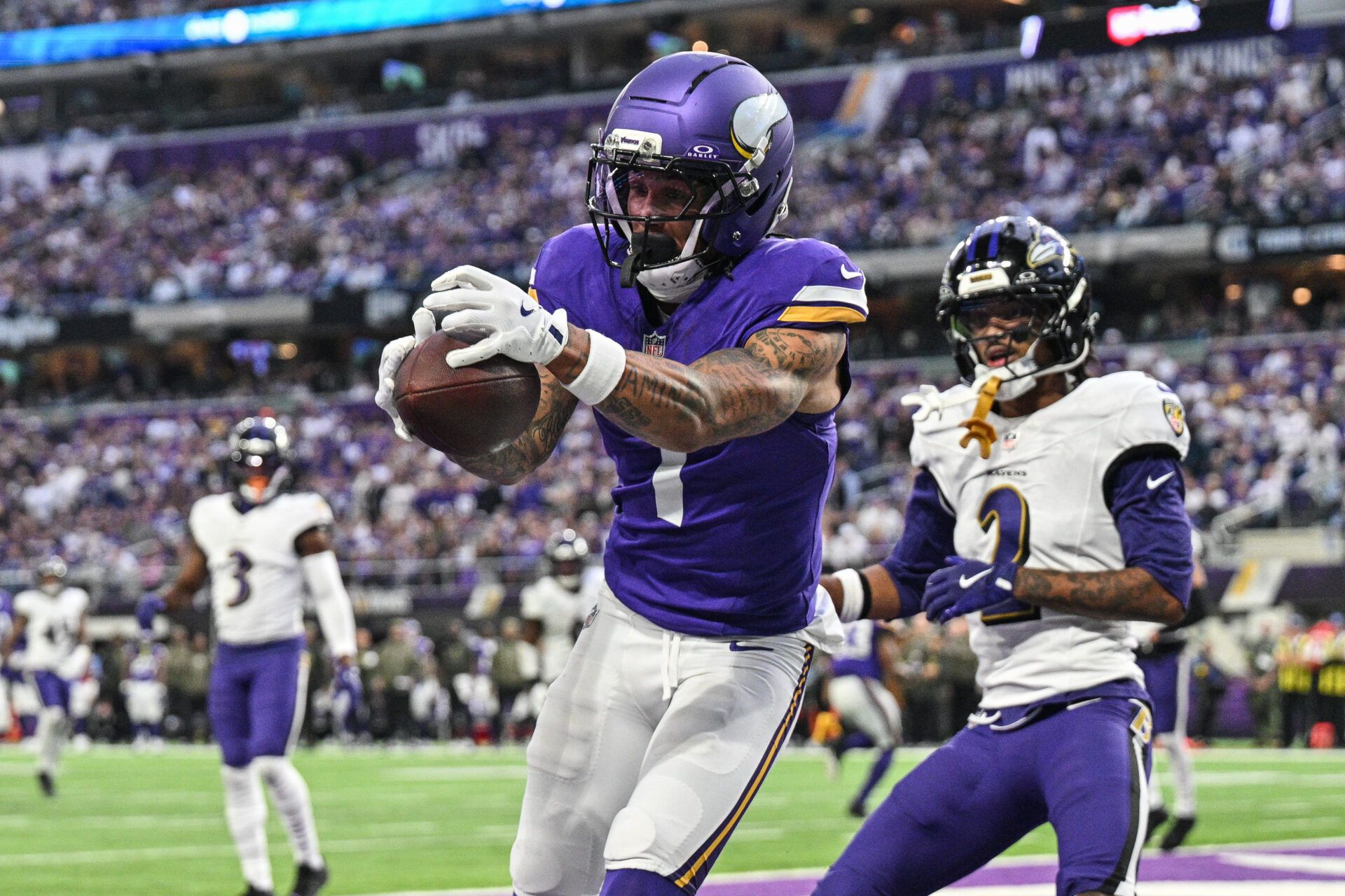 Minnesota Vikings wide receiver Jalen Nailor (1) scores on a touchdown pass as Baltimore Ravens cornerback Nate Wiggins (2) defends during the fourth quarter at U.S. Bank Stadium.