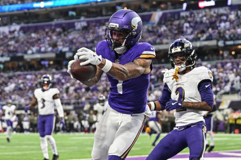 Minnesota Vikings wide receiver Jalen Nailor (1) scores on a touchdown pass as Baltimore Ravens cornerback Nate Wiggins (2) defends during the fourth quarter at U.S. Bank Stadium.
