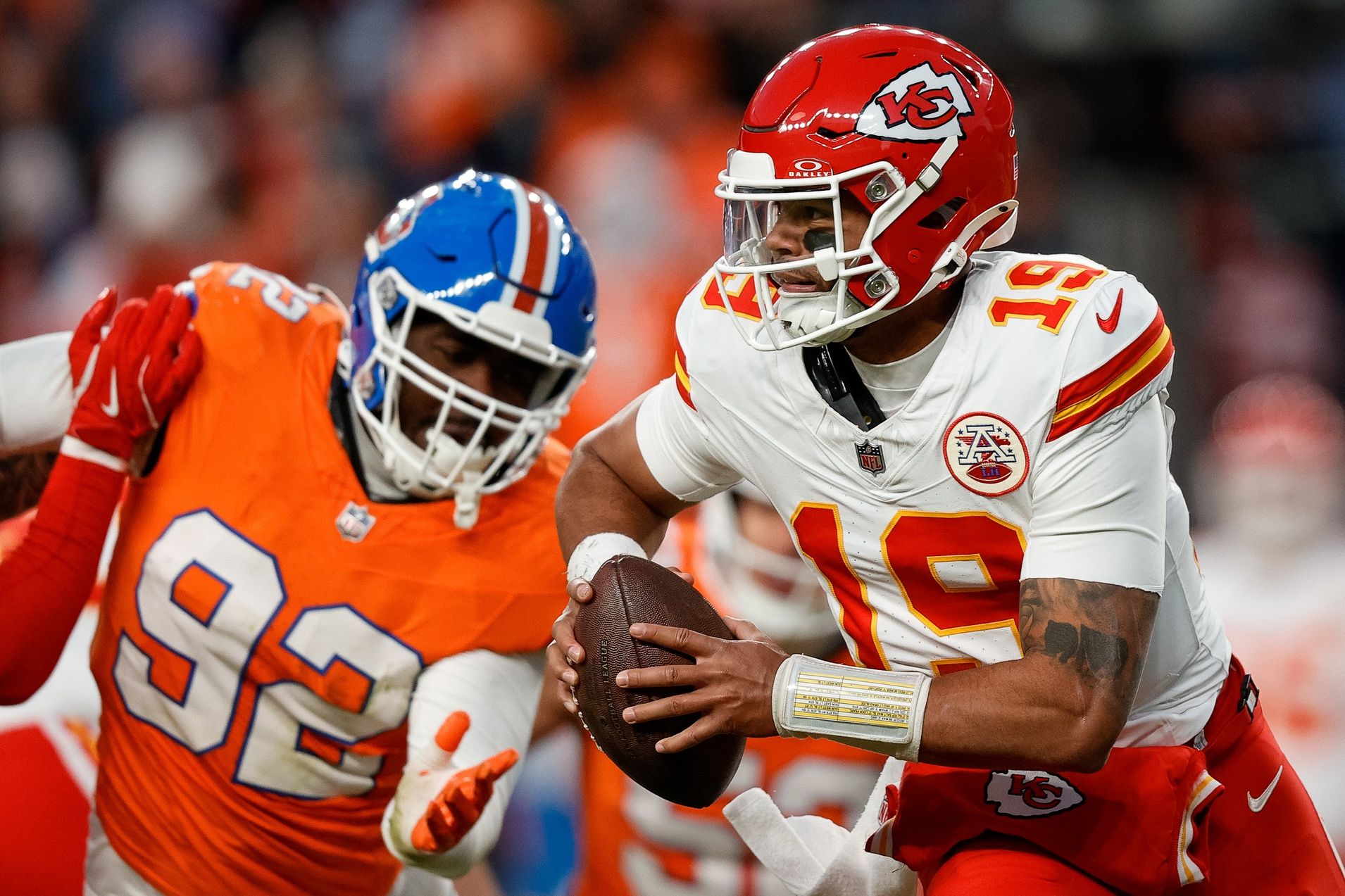 Kansas City Chiefs quarterback Chris Oladokun (19) scrambles under pressure from Denver Broncos linebacker Dondrea Tillman (92) in the fourth quarter at Empower Field at Mile High.