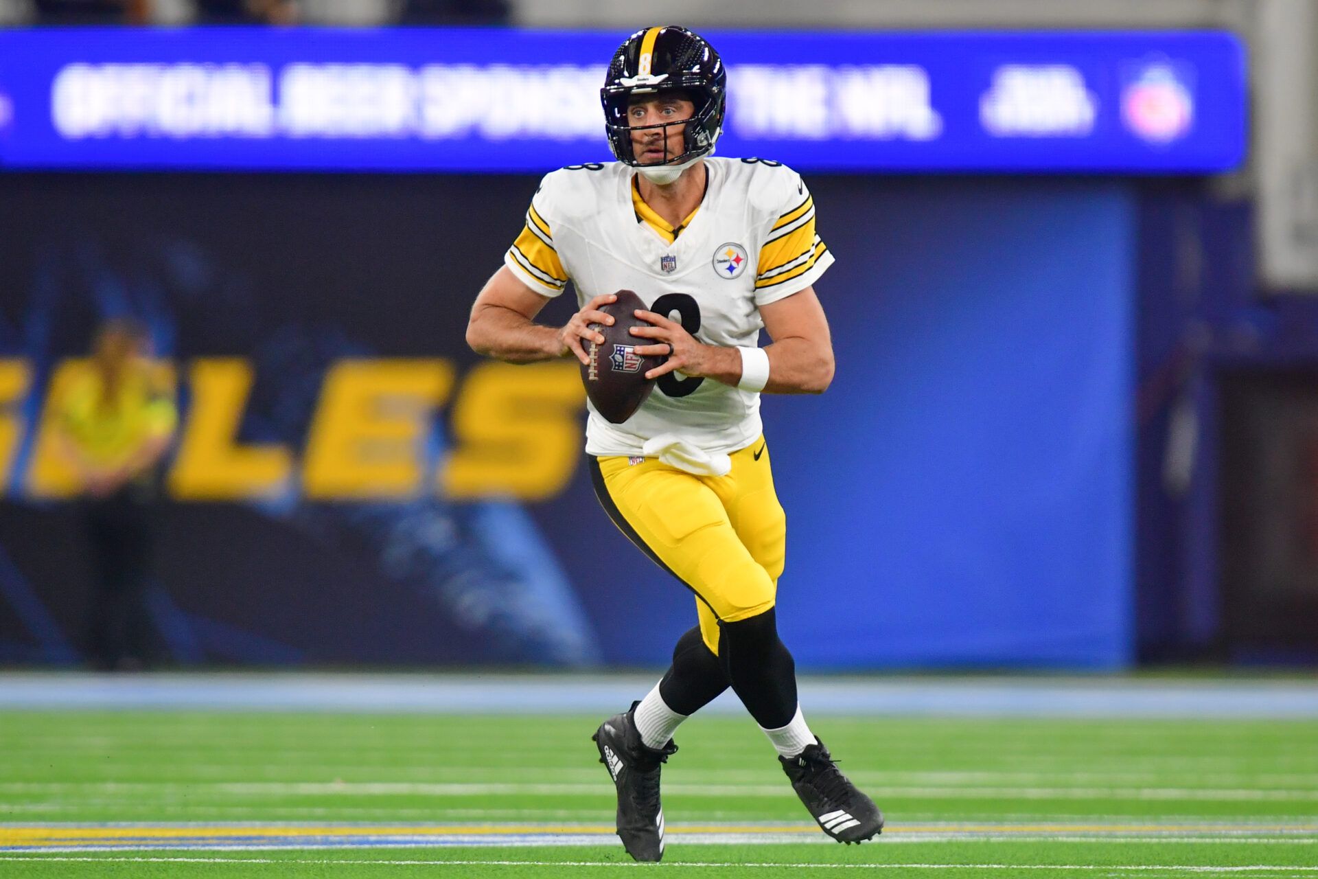 Pittsburgh Steelers quarterback Aaron Rodgers (8) scrambles with the ball against the Los Angeles Chargers during the first quarter of the game at SoFi Stadium.