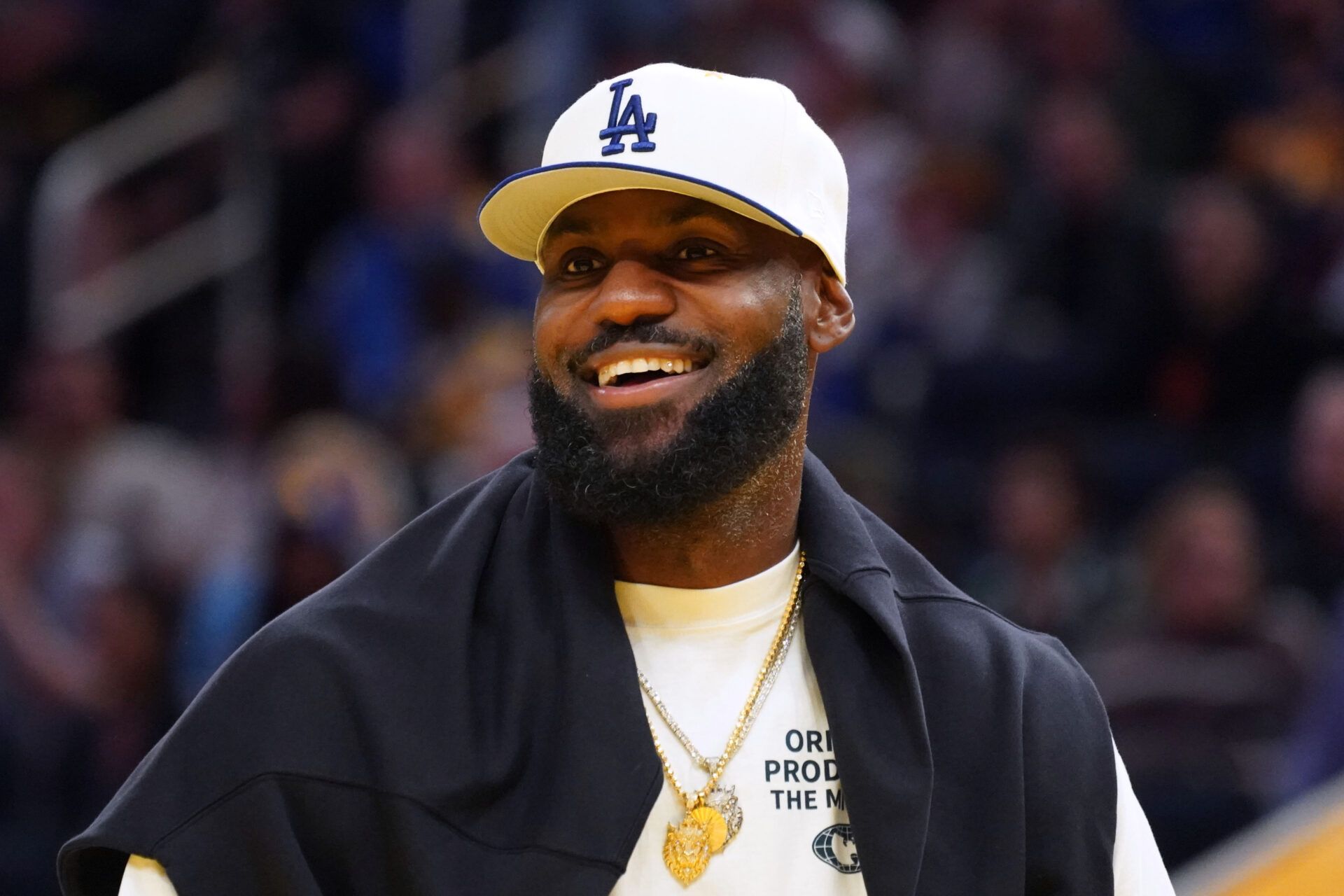 Los Angeles Lakers forward LeBron James (23), wearing a Los Angeles Dodgers hat, watches from the sideline during a break against the Golden State Warriors in the third quarter at Chase Center.