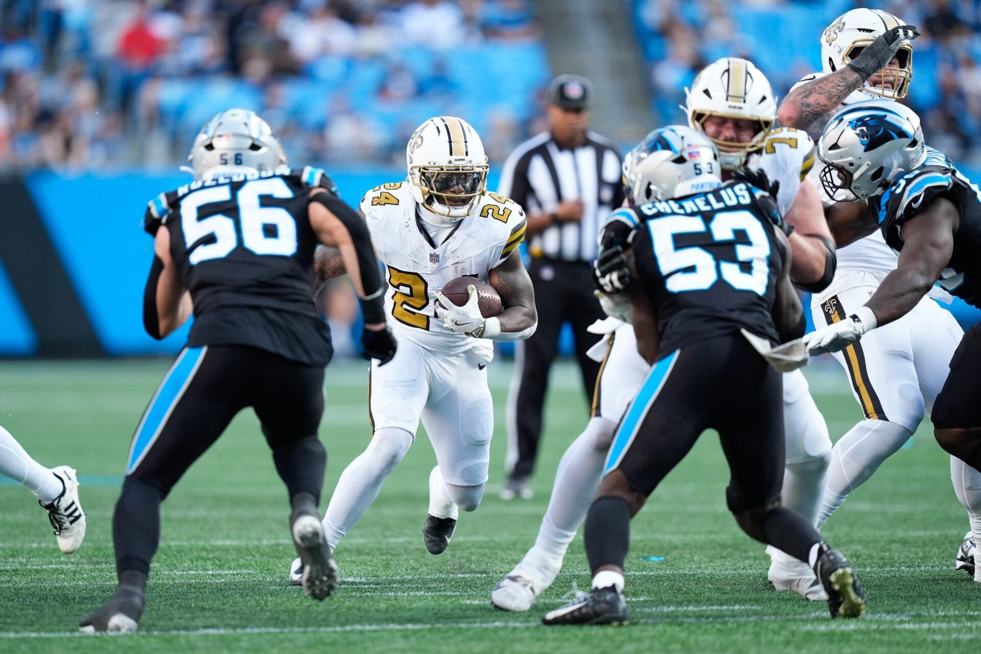 New Orleans Saints running back Devin Neal (24) rushes as Carolina Panthers linebacker Claudin Cherelus (53) and Carolina Panthers linebacker Christian Rozeboom (56) defend during the fourth quarter at Bank of America Stadium.