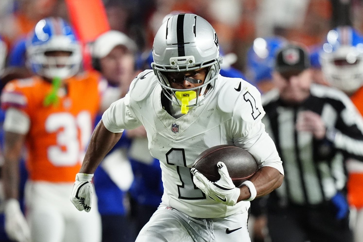 Las Vegas Raiders wide receiver Tre Tucker (1) runs with the ball after catch against the Denver Broncos during the first half at Empower Field at Mile High.
