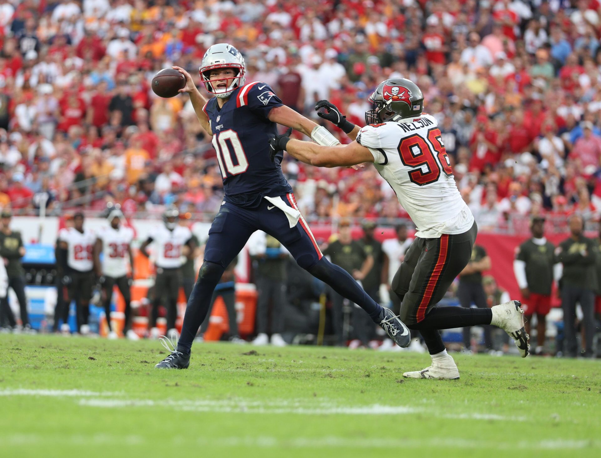 New England Patriots quarterback Drake Maye (10) throws downfield under pressure from Tampa Bay Buccaneers linebacker Anthony Nelson (98) during the fourth quarter at Raymond James Stadium.