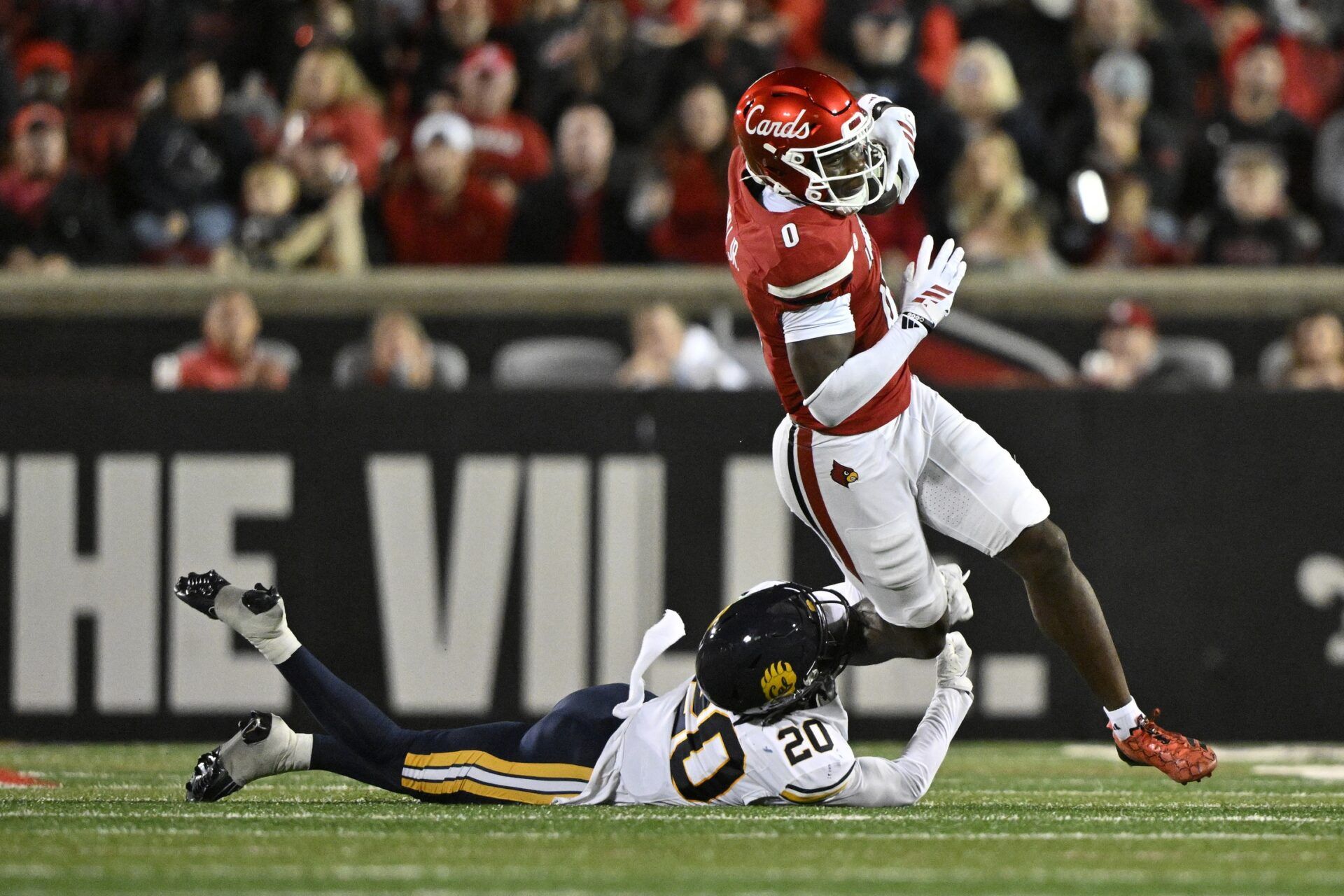 Louisville Cardinals wide receiver Chris Bell (0) attempts escape the tackle of California Golden Bears defensive back Cam Sidney (20) during the first half at L&N Federal Credit Union Stadium.