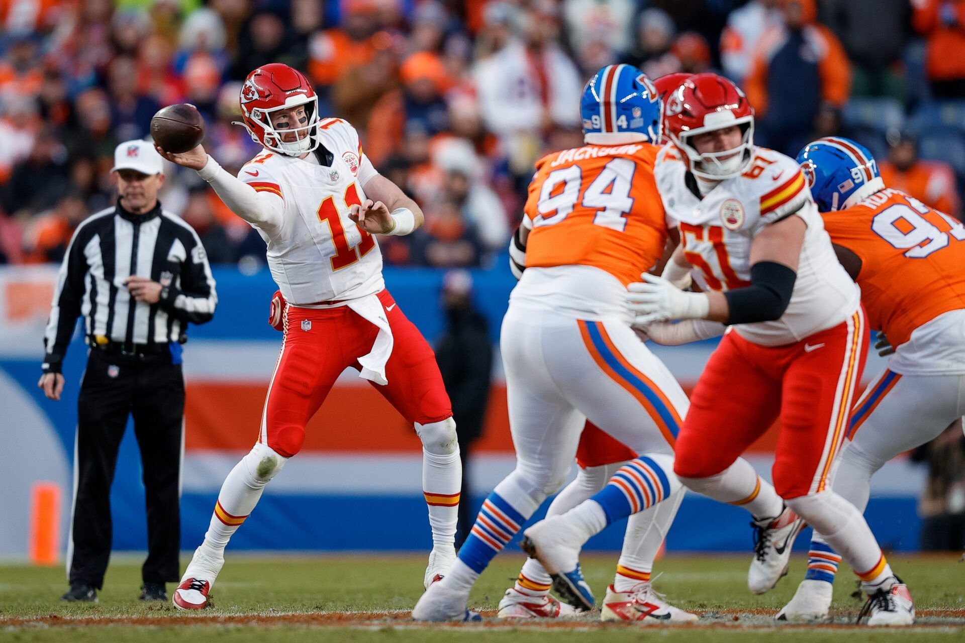 Kansas City Chiefs quarterback Carson Wentz (11) attempts a pass as Denver Broncos defensive tackle Jordan Jackson (94) and defensive tackle Malcolm Roach (97) defend as guard C.J. Hanson (61) looks for position in the third quarter at Empower Field at Mile High.