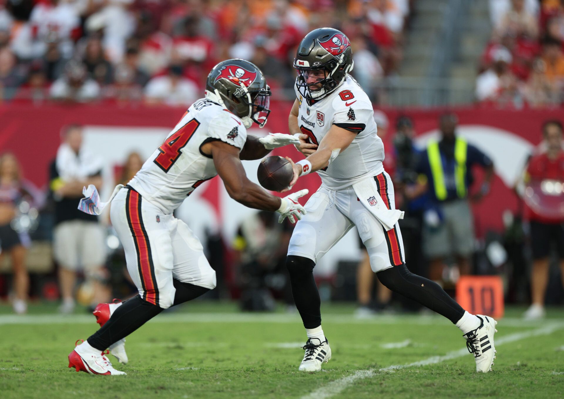 Tampa Bay Buccaneers quarterback Baker Mayfield (6) hands the ball off to wide receiver Chris Godwin Jr. (14) during the fourth quarter against the San Francisco 49ers at Raymond James Stadium.