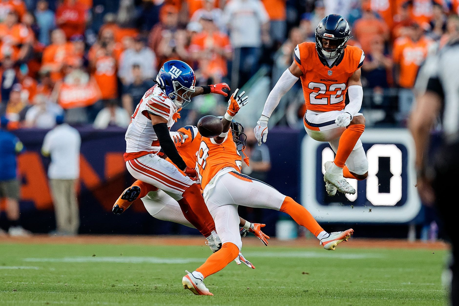 New York Giants wide receiver Wan'Dale Robinson (17) is unable to pull in a pass under pressure from Denver Broncos cornerback Ja'Quan McMillian (29) and cornerback Pat Surtain II (2) defend as safety Brandon Jones (22) defends in the fourth quarter at Empower Field at Mile High.