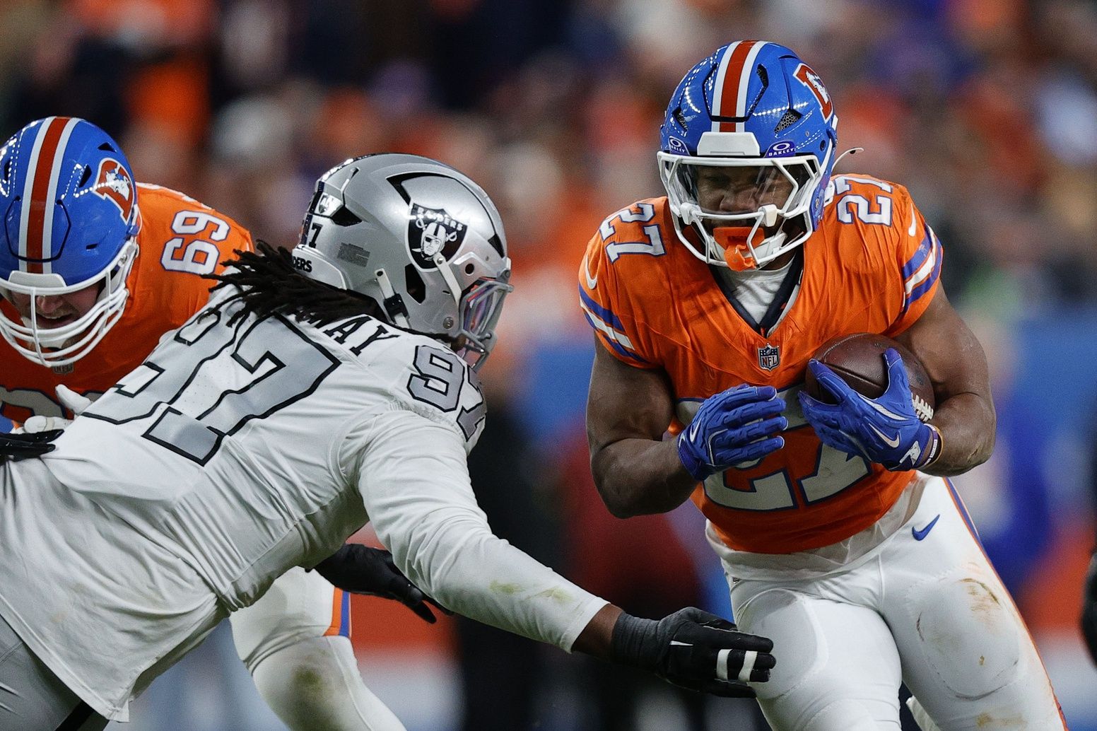 Denver Broncos running back J.K. Dobbins (27) rushes the ball against the Las Vegas Raiders during the second half at Empower Field at Mile High.