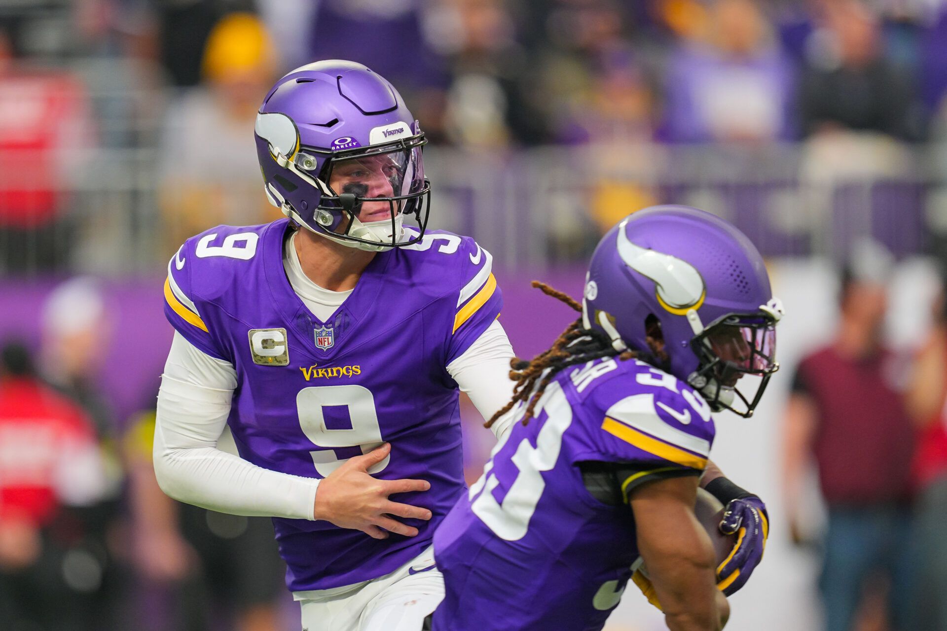 Minnesota Vikings quarterback J.J. McCarthy (9) hands the ball off to running back Aaron Jones Sr. (33) against the Baltimore Ravens in the second quarter at U.S. Bank Stadium.