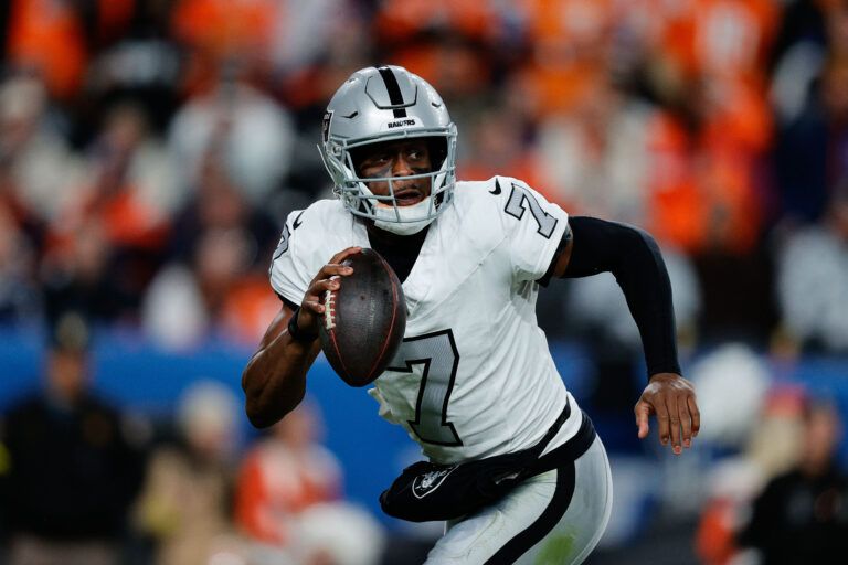 Las Vegas Raiders quarterback Geno Smith (7) scrambles with the ball in the fourth quarter against the Denver Broncos at Empower Field at Mile High.