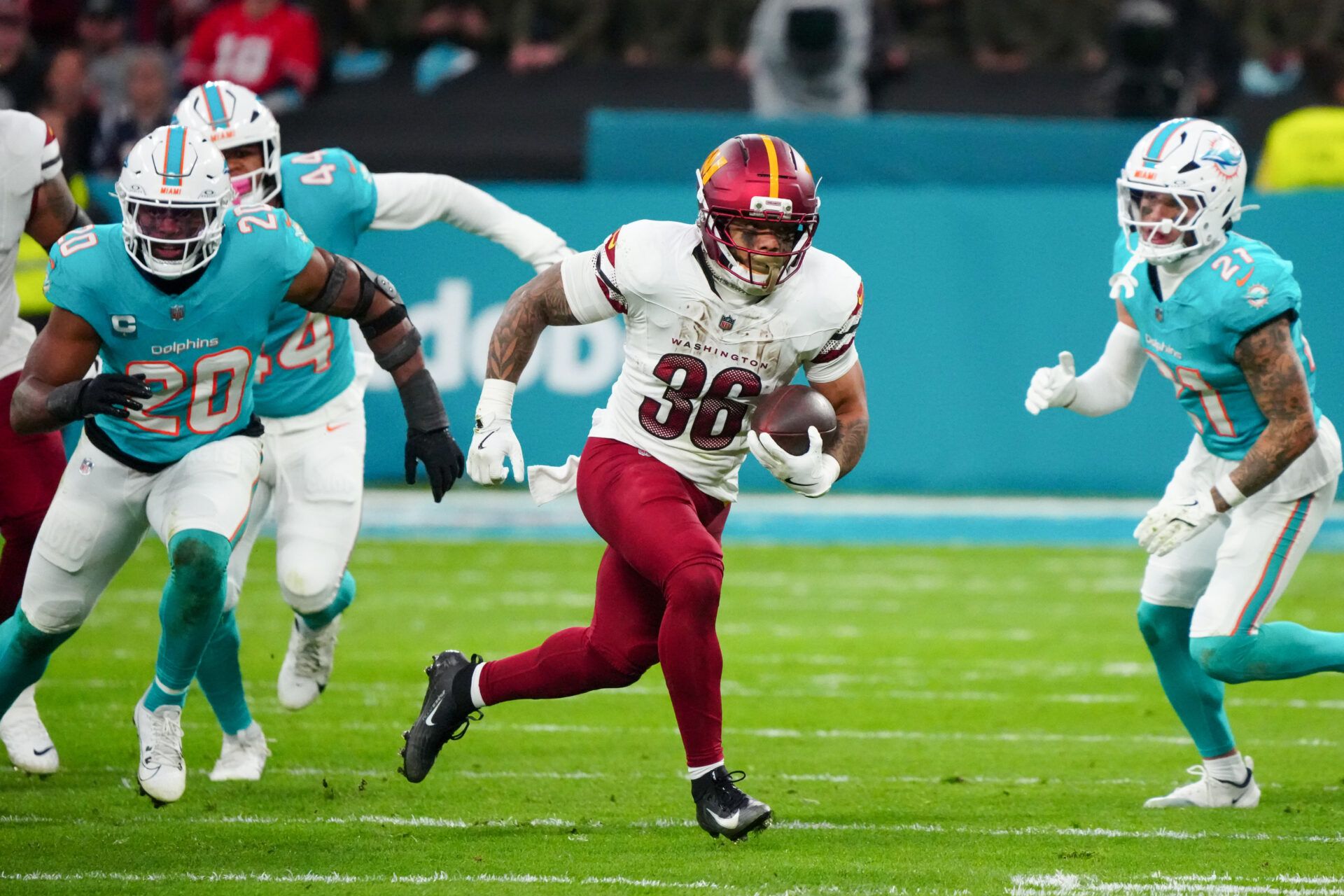 Washington Commanders running back Chris Rodriguez Jr. (36) carries the ball against the Miami Dolphins in the second quarter during the 2025 NFL Madrid Game at Santiago Bernabeu Stadium.