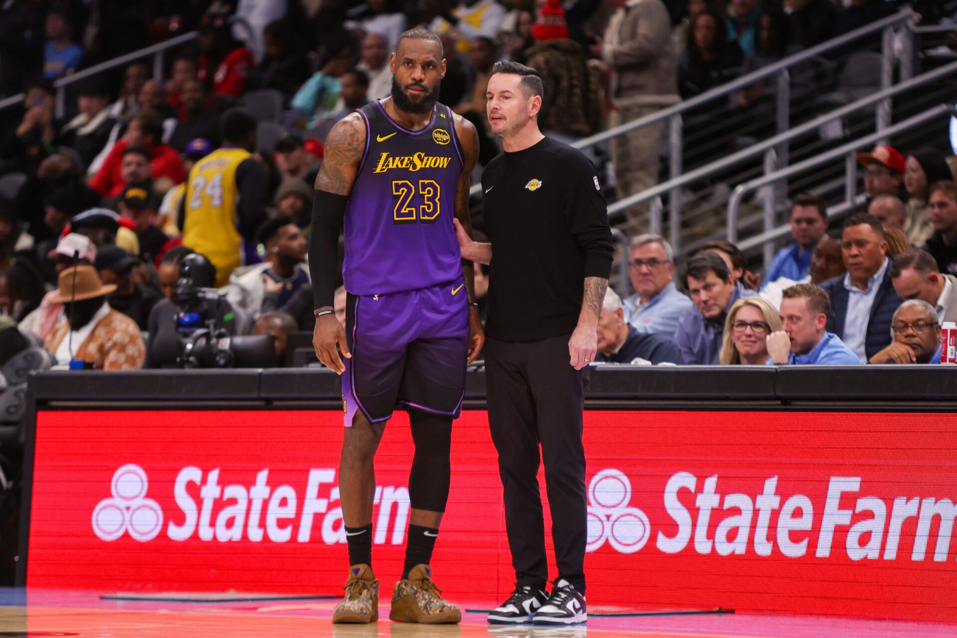 Los Angeles Lakers forward LeBron James (23) talks to head coach JJ Redick against the Atlanta Hawks in the second quarter at State Farm Arena.