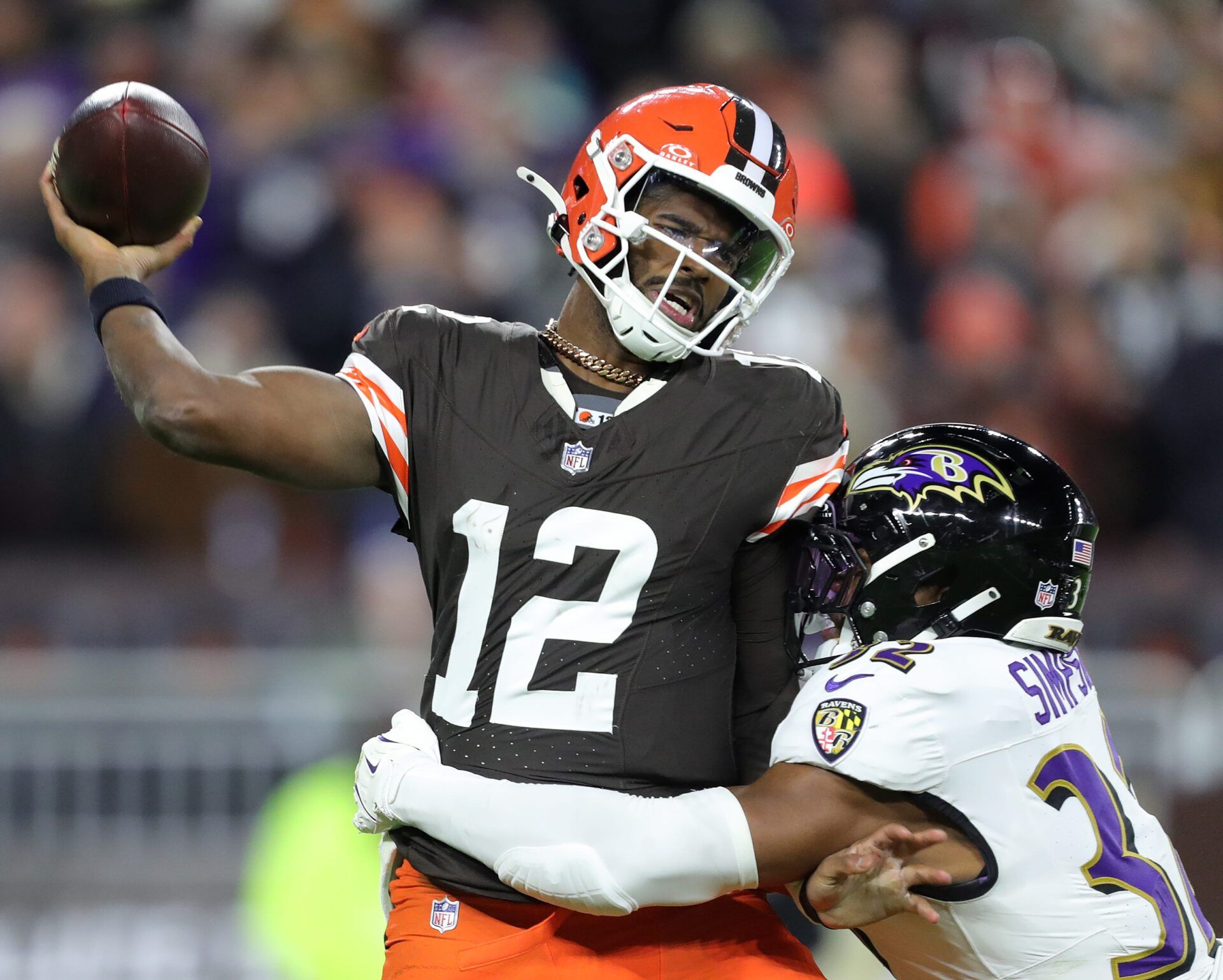 Cleveland Browns quarterback Shedeur Sanders (12) is hit by Baltimore Ravens linebacker Trenton Simpson (32) during the second half of an NFL football game at Huntington Bank Field, Nov. 16, 2025, in Cleveland, Ohio.