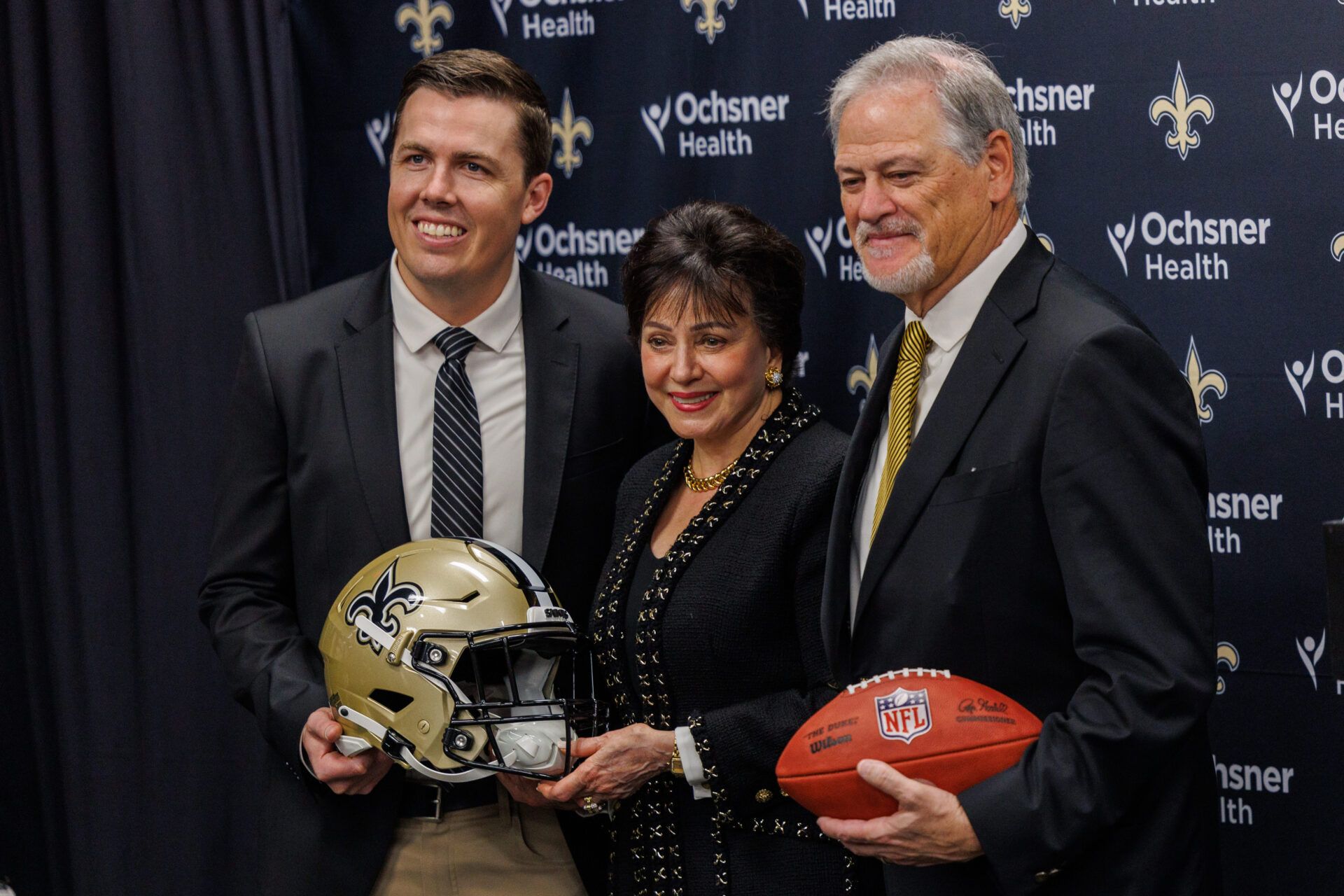 New Orleans Saints owner Gayle Benson poses with head coach Kellen Moore and general manager Mickey Loomis at Ochsner Sports Performance Center.
