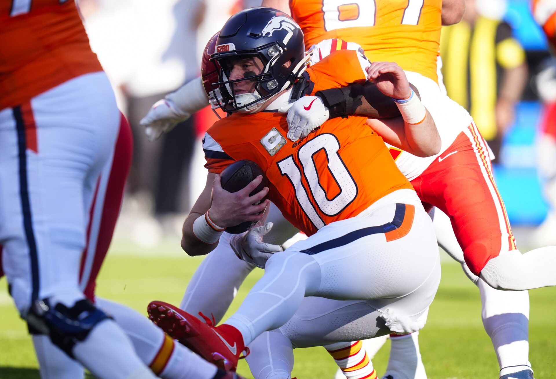 Kansas City Chiefs safety Chamarri Conner (27) sacks Denver Broncos quarterback Bo Nix (10) during the first quarter of the game at Empower Field at Mile High.