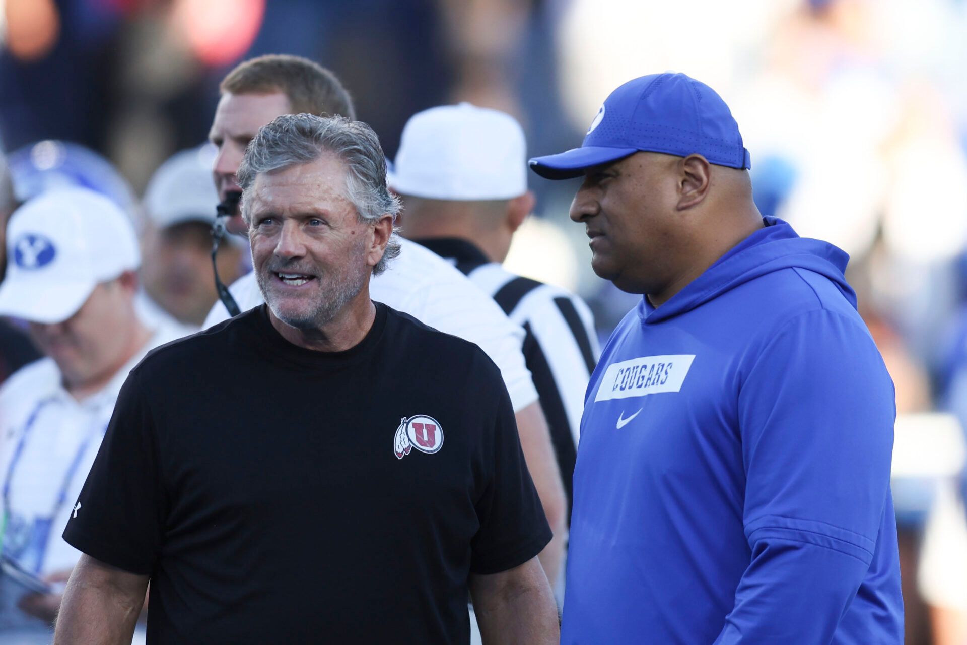 Utah Utes head coach Kyle Whittingham (left) and BYU Cougars head coach Kalani Sitake (right) speak before a game at LaVell Edwards Stadium.