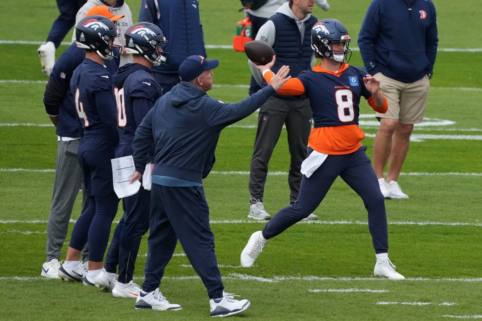 Denver Broncos quarterback Jarrett Stidham (8) throws the ball as head coach Sean Payton and quarterbacks Sam Ehlinger (4) and Bo Nix (10) watch during practice at the Hanbury Manor.