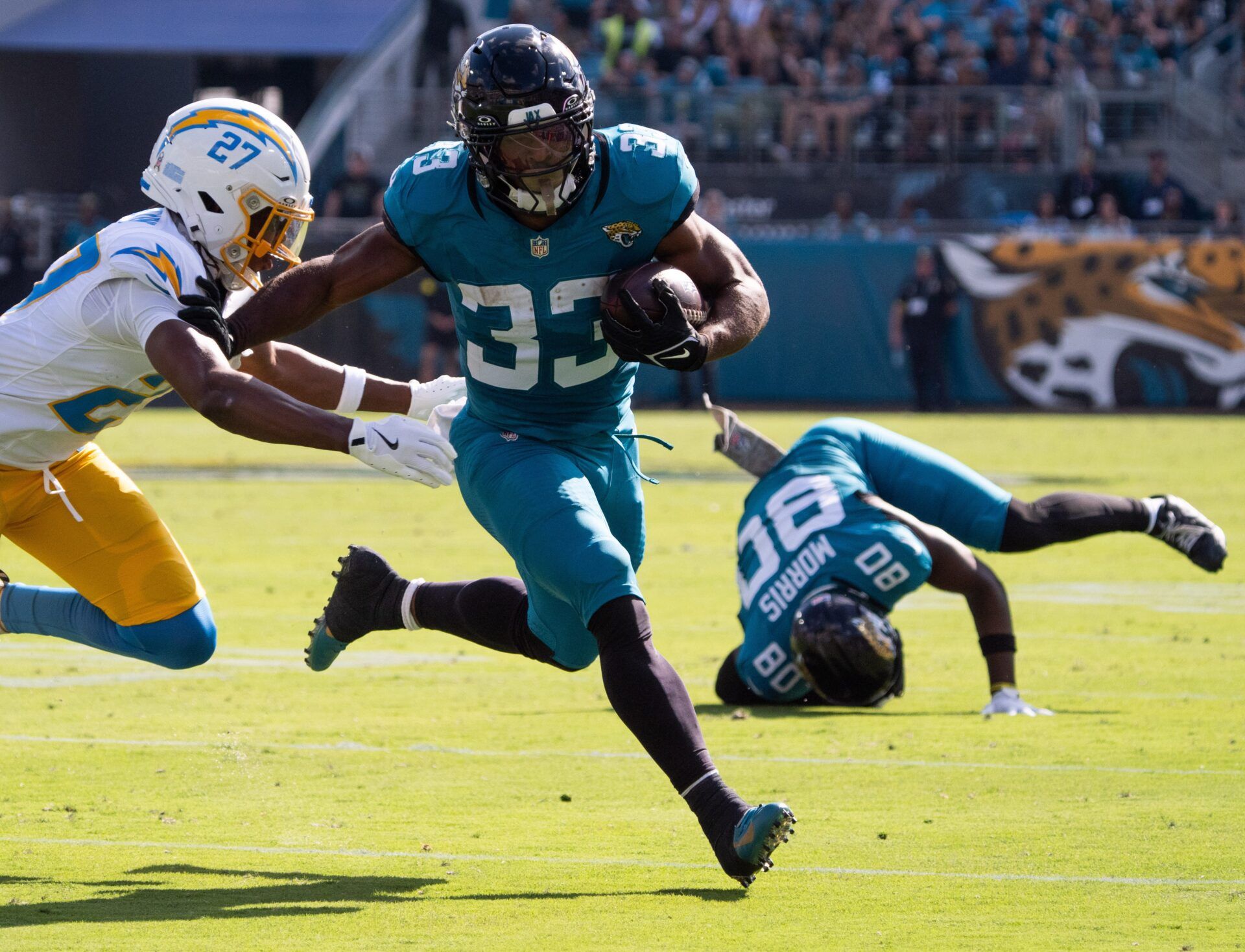 Jacksonville Jaguars running back Bhayshul Tuten (33) eludes a tackle in the second quarter as Los Angeles Chargers safety R.J. Mickens (27) tries to tackle him in an NFL football game at EverBank Stadium, Sunday, November 16, 2025, in Jacksonville, Fla. [Doug Engle/Florida Times-Union]
