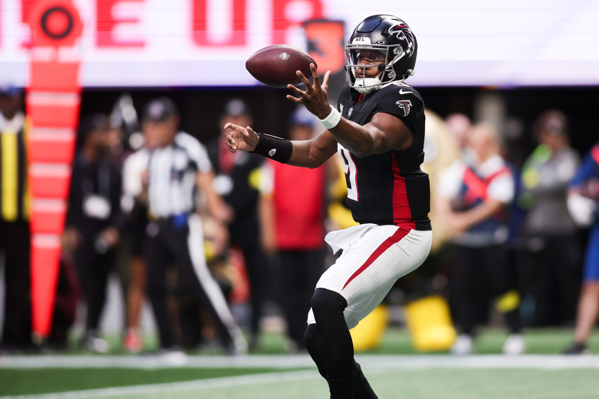 Atlanta Falcons quarterback Michael Penix Jr. (9) reaches for a bad snap in the third quarter against the Carolina Panthers at Mercedes-Benz Stadium.