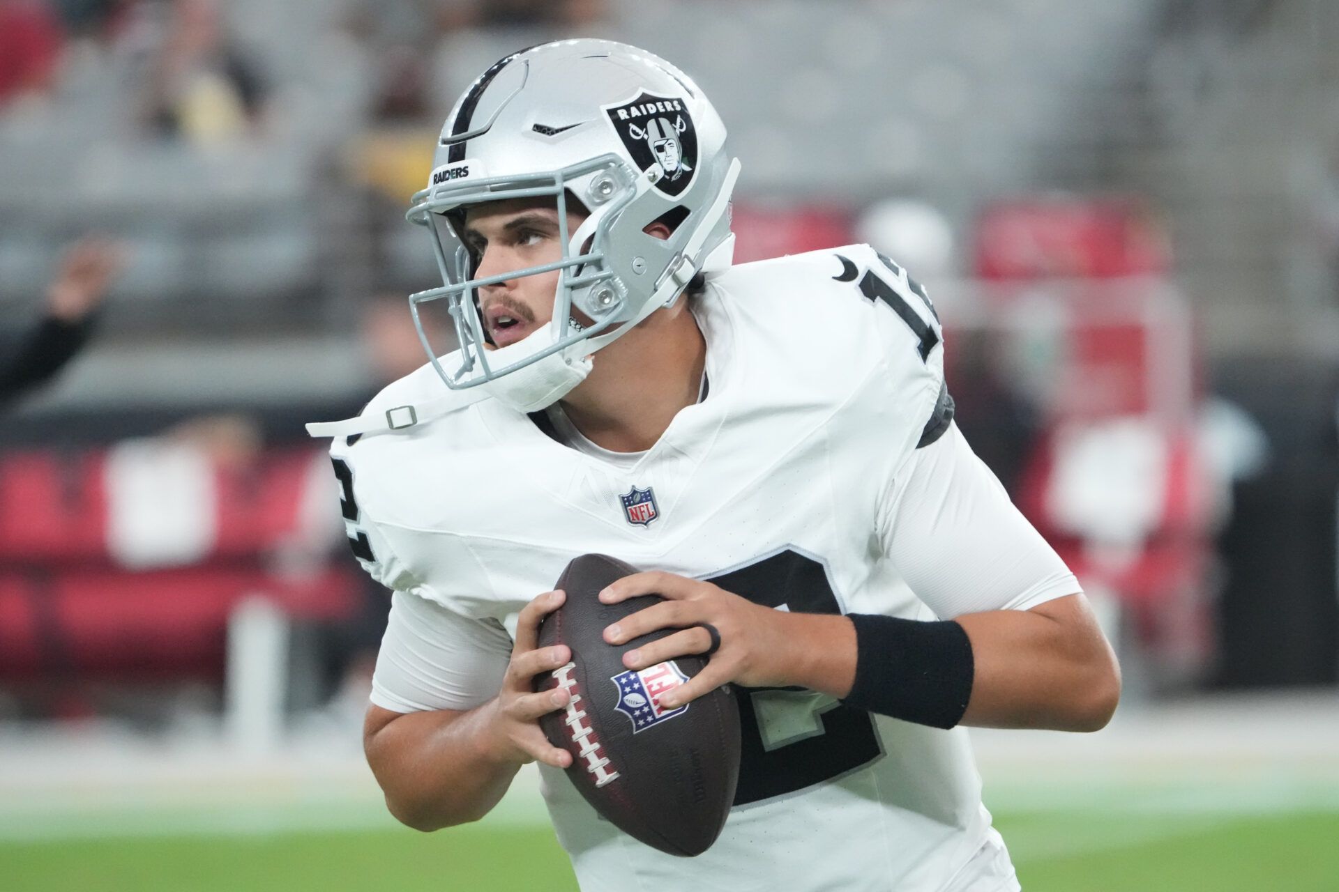 Las Vegas Raiders quarterback Aidan O'Connell (12) warms up before the game against the Arizona Cardinals at State Farm Stadium.