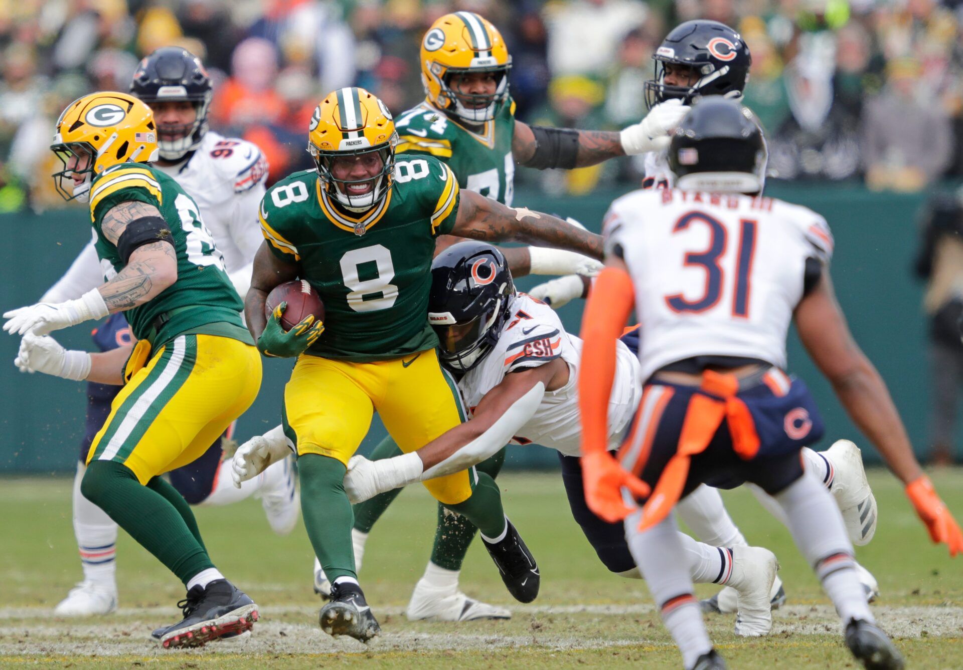 Green Bay Packers running back Josh Jacobs (8) runs for a first down against Chicago Bears defensive tackle Chris Williams (91) in the first quarter during their football game Sunday, January 5, 2025, at Lambeau Field in Green Bay, Wisconsin.