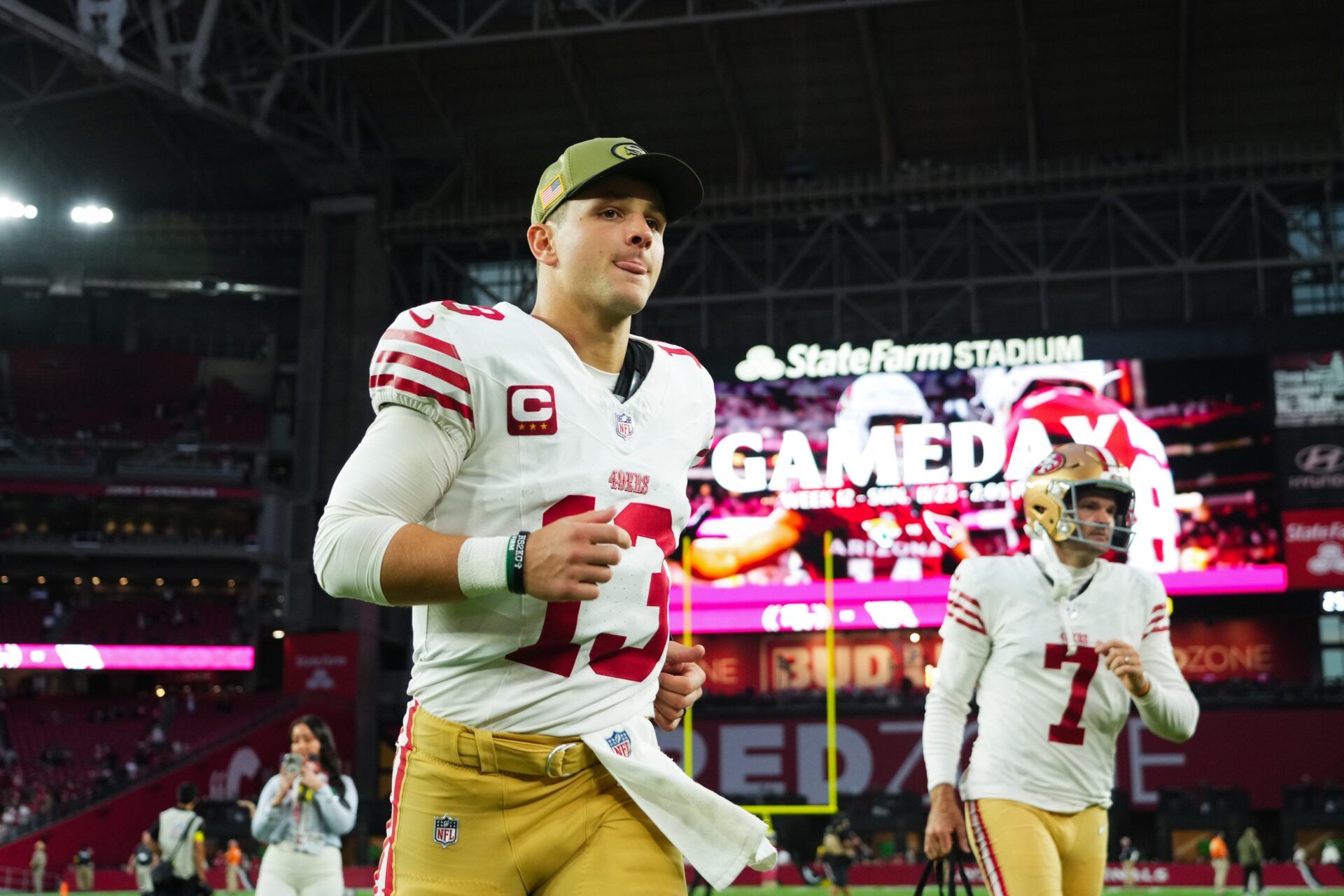 San Francisco 49ers quarterback Brock Purdy (13) runs off the field after defeating the Arizona Cardinals at State Farm Stadium.