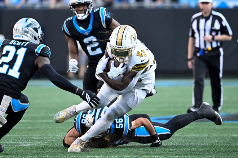 New Orleans Saints running back Alvin Kamara (41) with the ball as Carolina Panthers safety Nick Scott (21) and cornerback Mike Jackson (2) and linebacker Christian Rozeboom (56) defend in the fourth quarter at Bank of America Stadium.